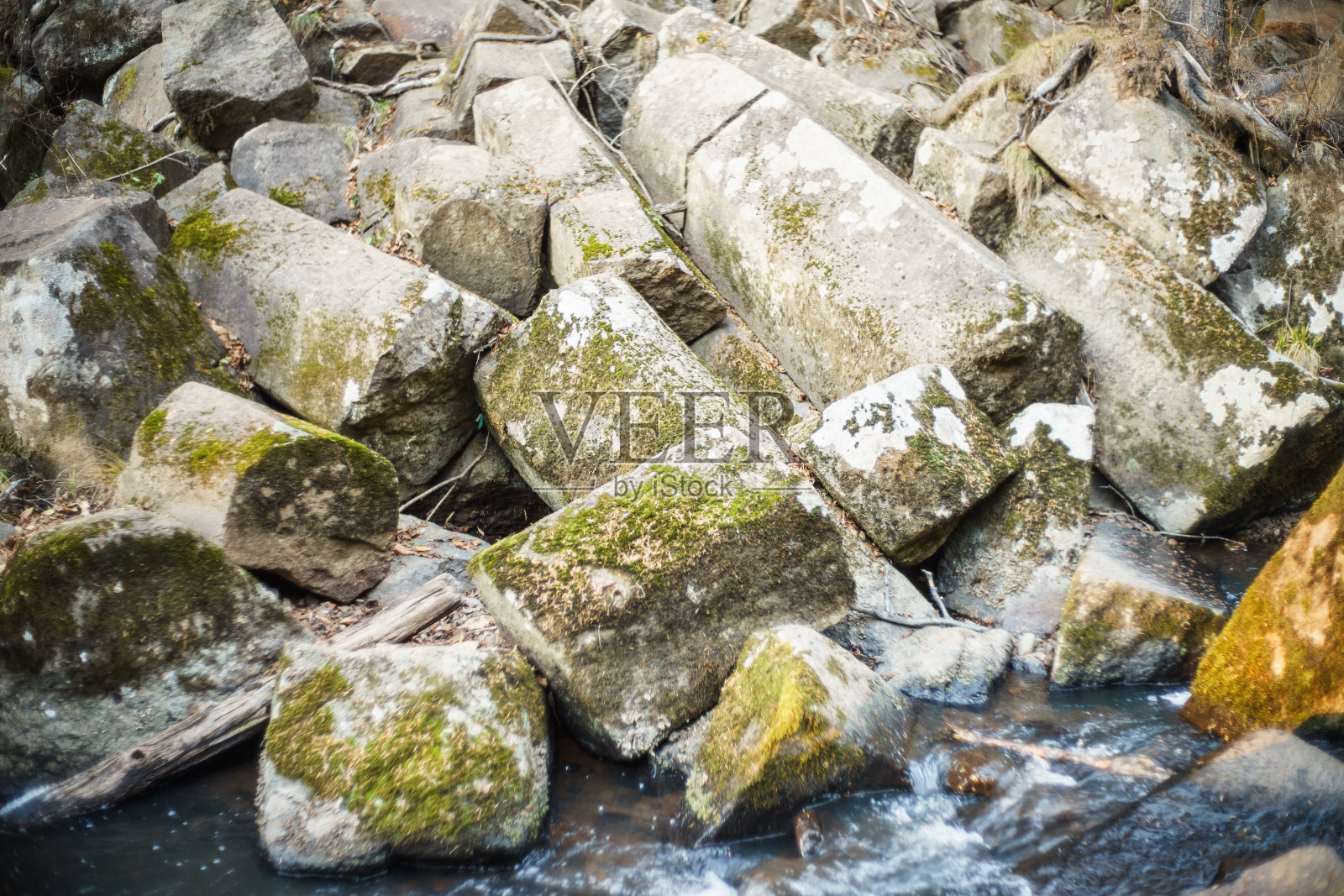 小溪岸边的碎岩石。神奇的天然五角形石块。照片摄影图片