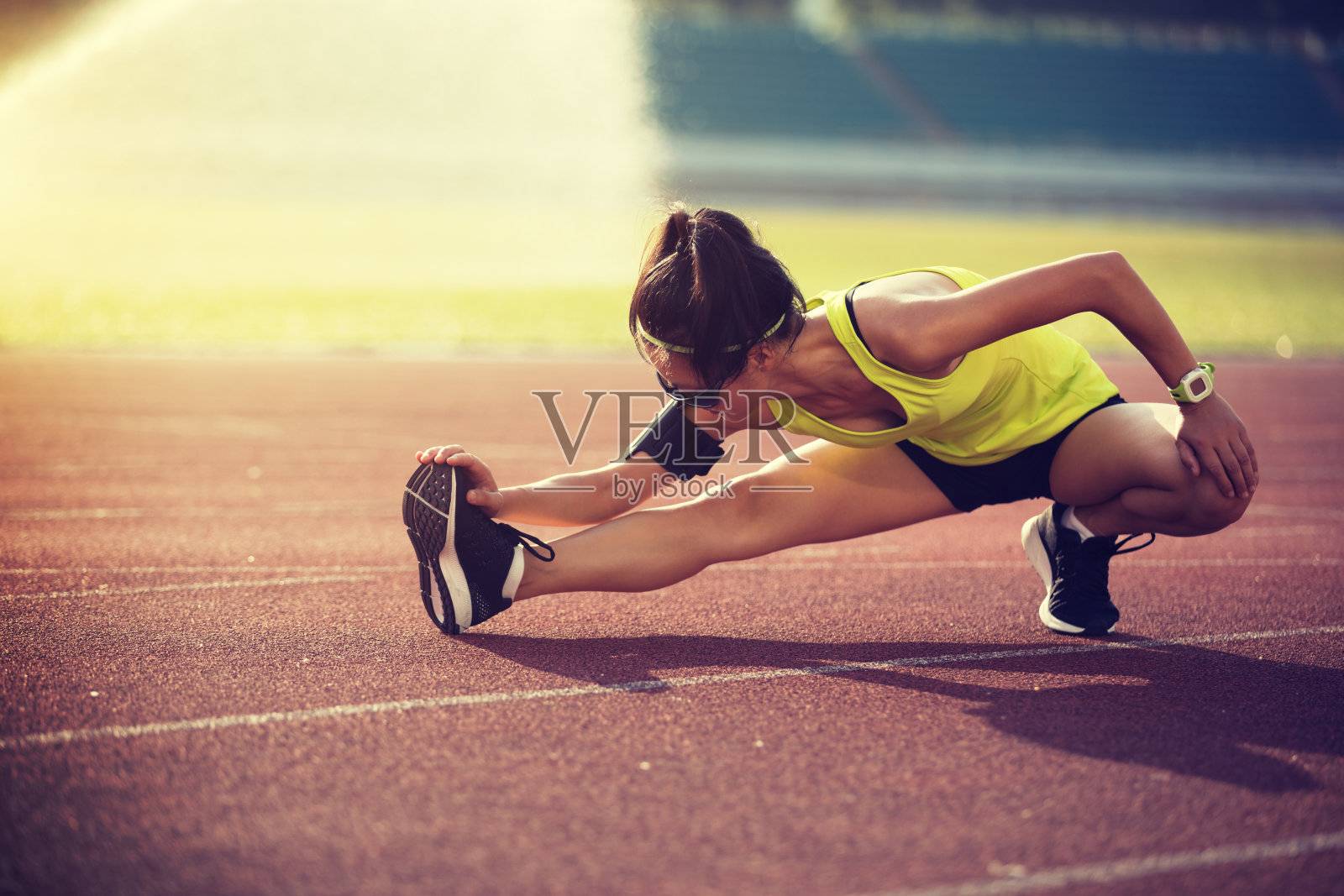 女运动员在体育场跑步前伸展照片摄影图片