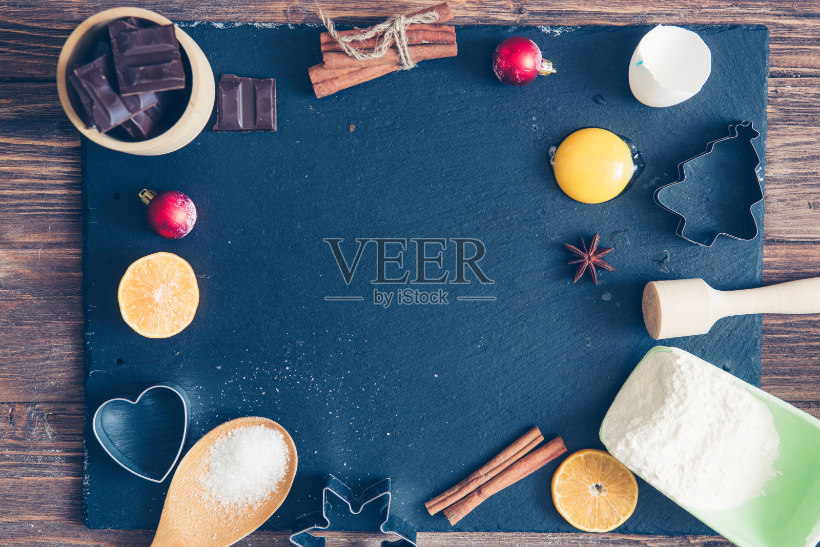 圣诞节，冬天烤饼干的配料。面粉，蔓越莓，橙子干，肉桂，香料放在一个黑色的石头桌子上，俯视图的文本拷贝空间照片摄影图片