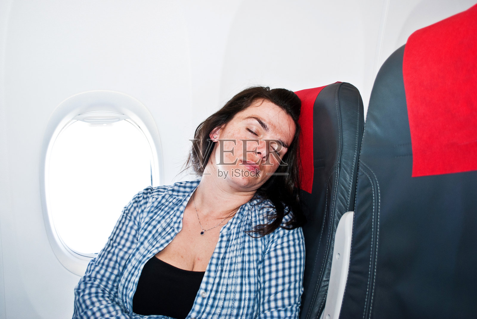 睡在飞机上的疲惫女人照片摄影图片
