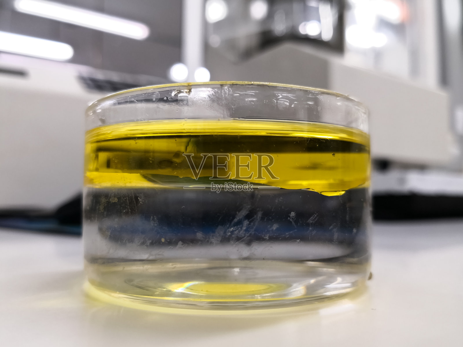 水和油的界面，两种不相容的液体，在一个科学实验室烧杯照片摄影图片