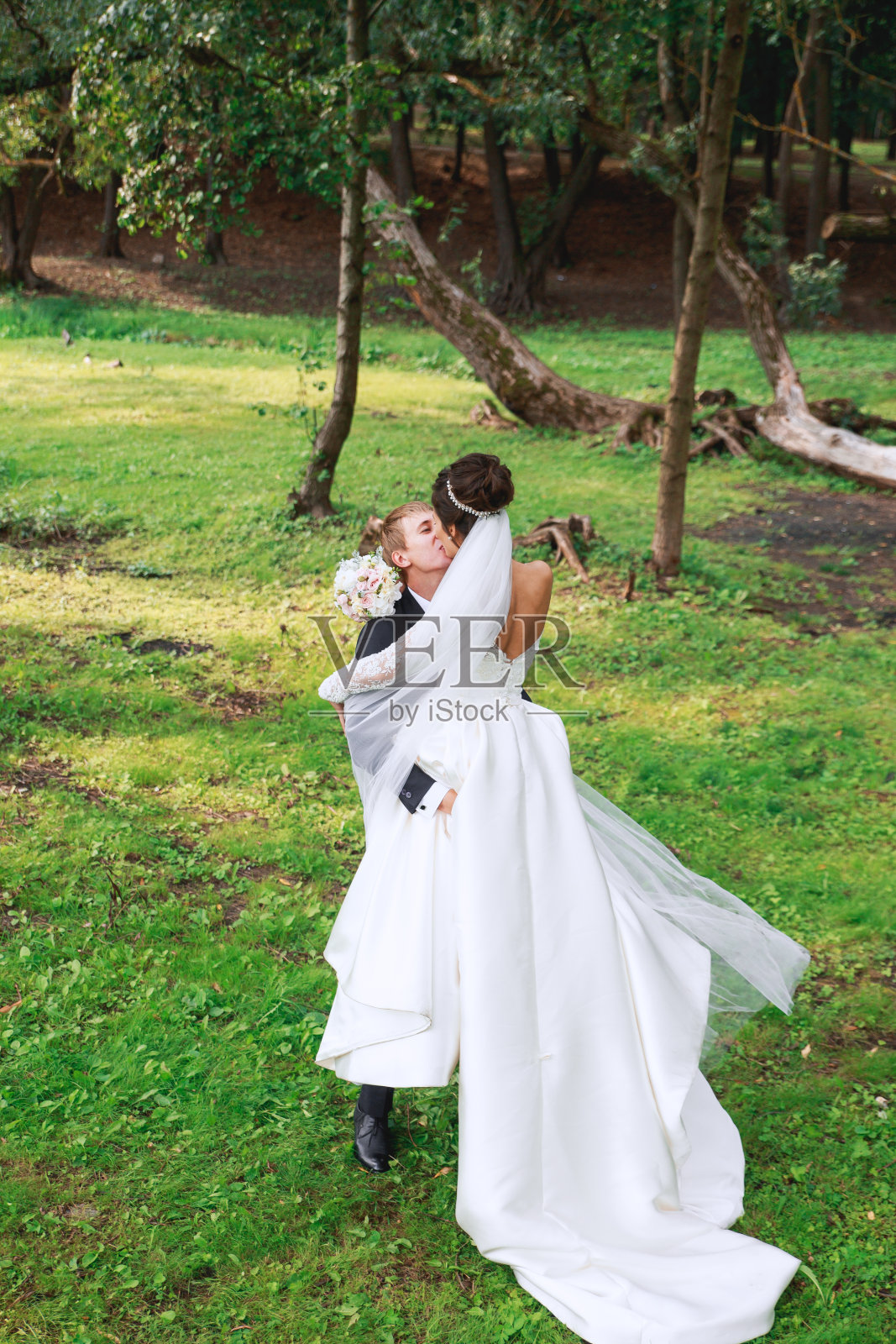 快乐的新娘和新郎在婚礼后拥抱和亲吻照片摄影图片