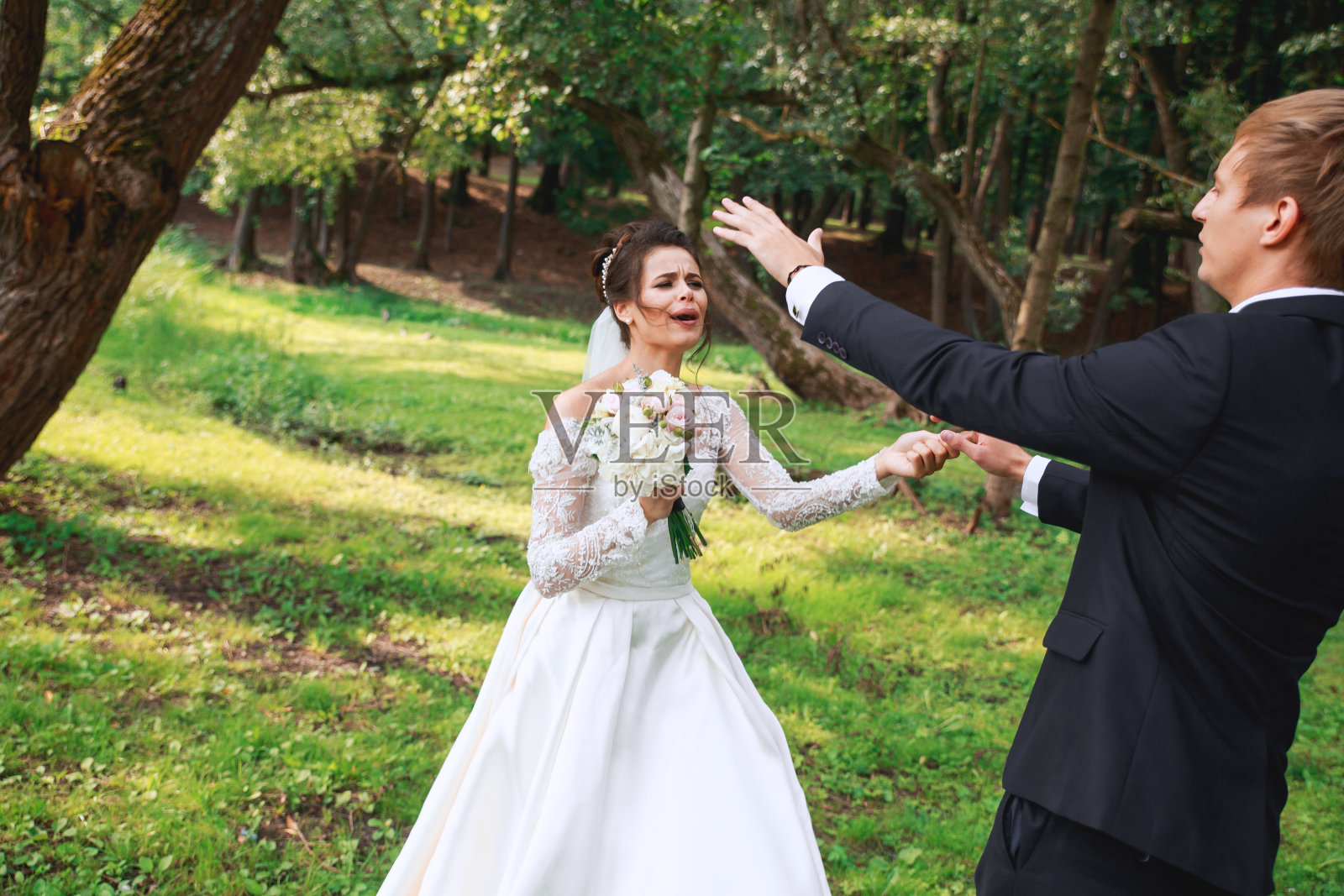快乐英俊的新郎和美丽的新娘在公园里欢笑跳舞照片摄影图片
