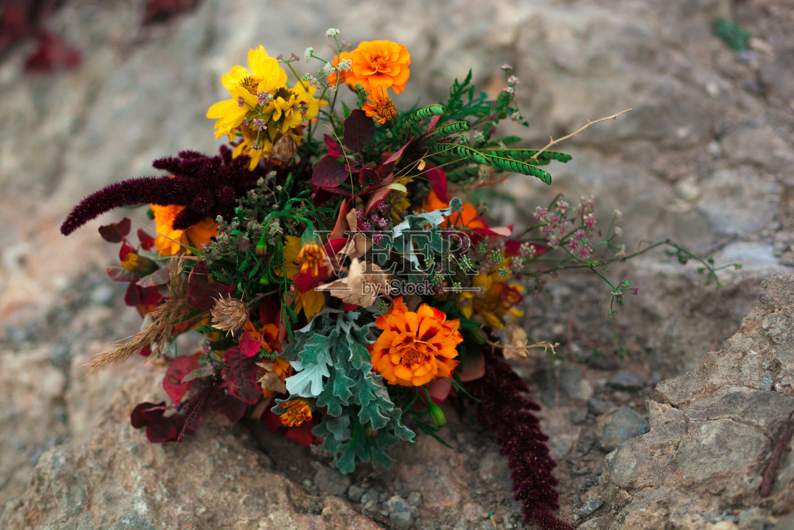 婚礼花束在一个明亮的秋天风格。在石头的背景岩石。万寿菊鲜花照片摄影图片