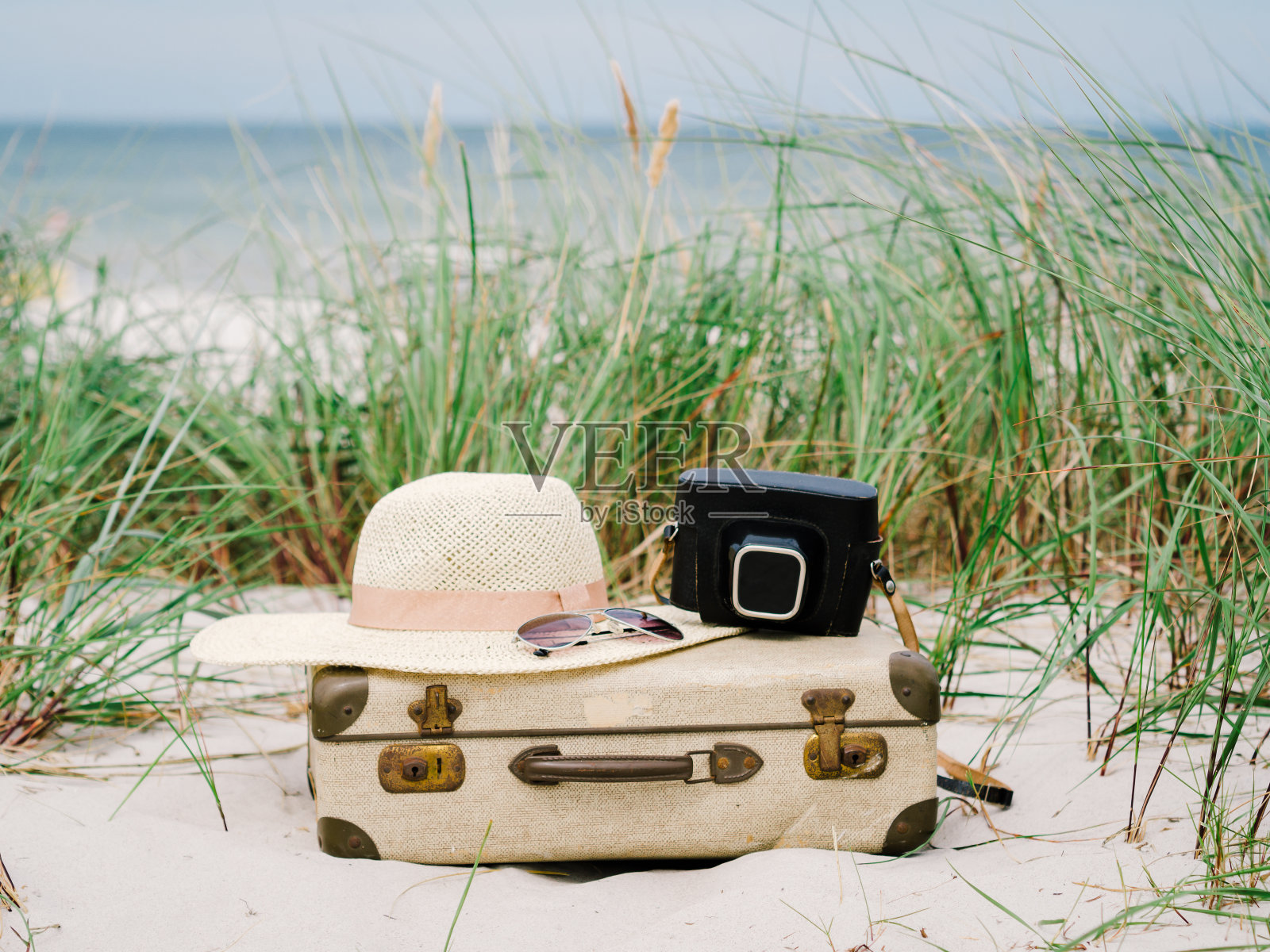 复古行李箱，夏日帽子，沙丘上的复古相机照片摄影图片