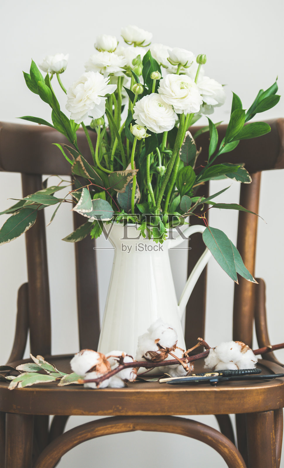 春天白色毛茛花在珐琅壶上的椅子照片摄影图片