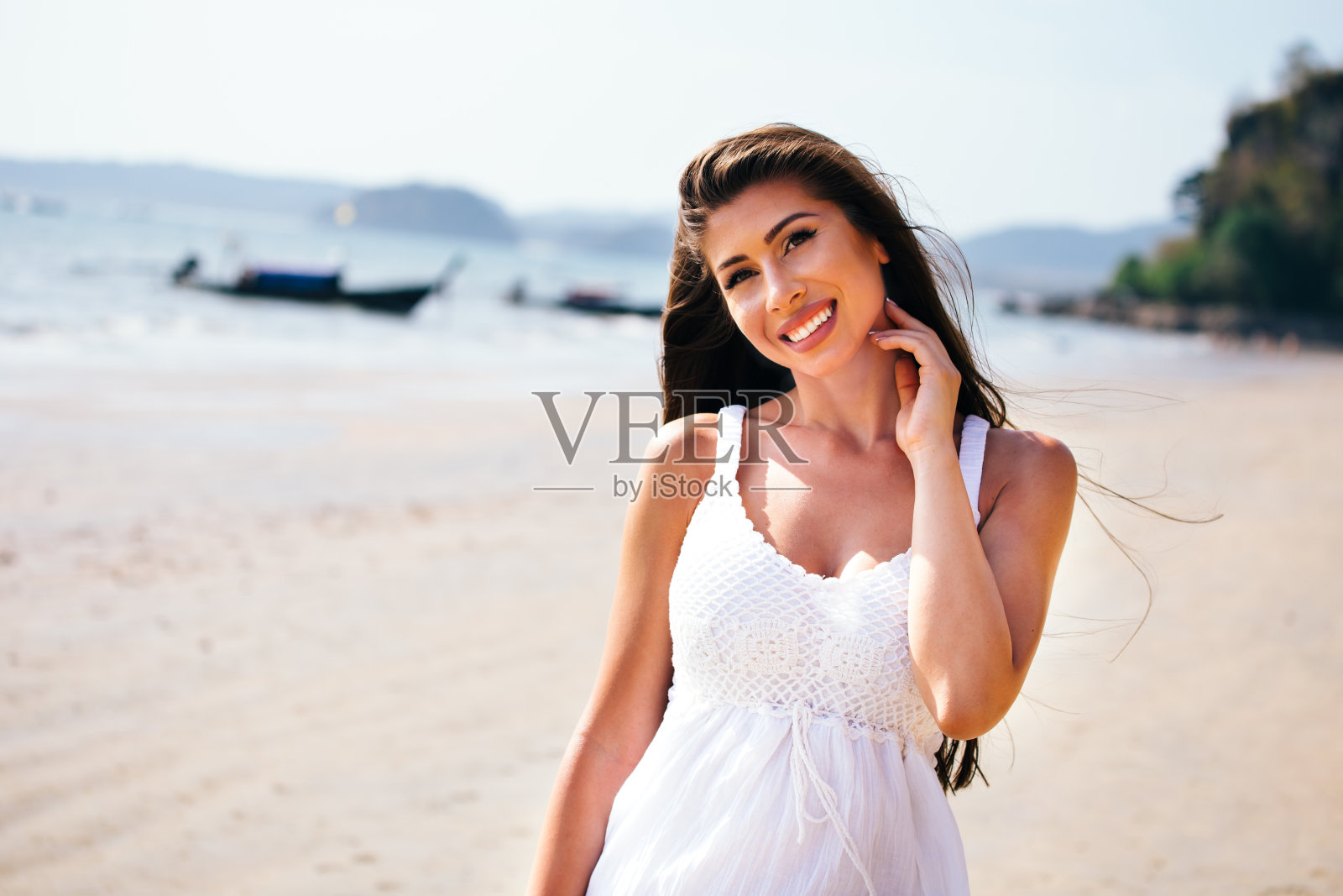年轻快乐有吸引力和美丽的白人成年妇女微笑在白色的夏季连衣裙在热带海滩上的腰向上的shot照片摄影图片