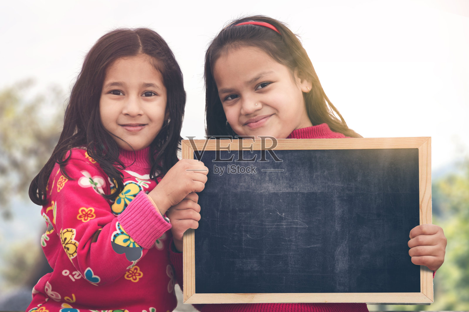 两个快乐的孩子拿着空白的黑板。教育激励的概念。照片摄影图片