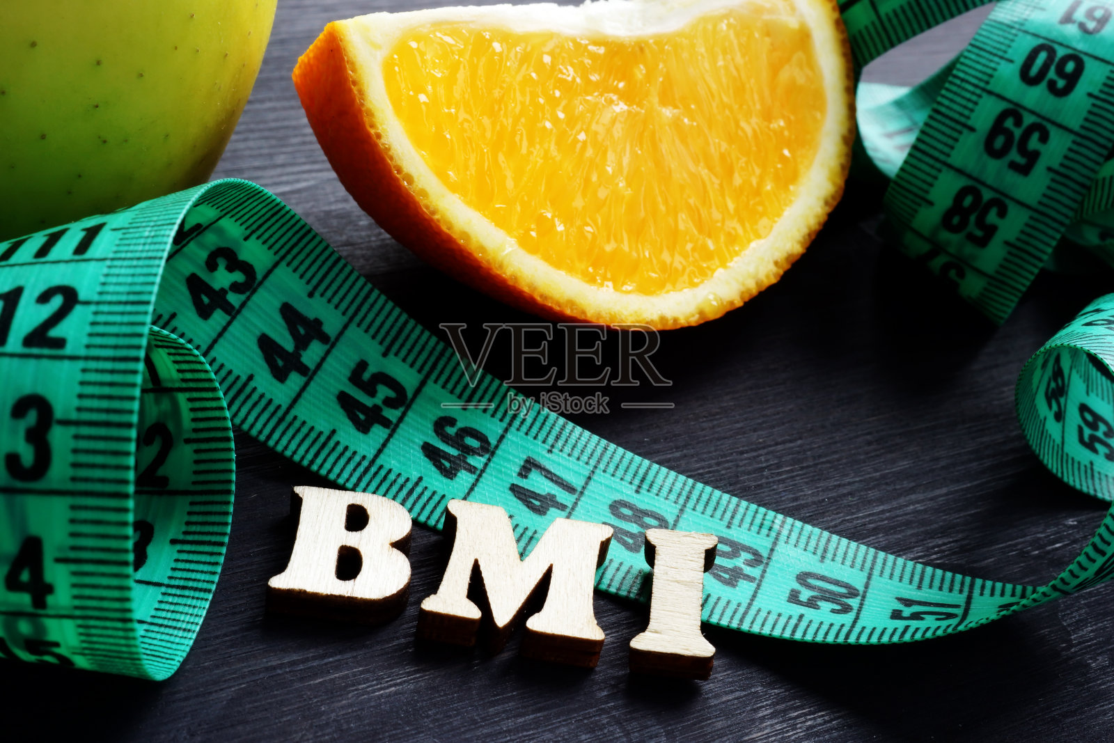 字母BMI身体质量指数与卷尺和橙色。照片摄影图片