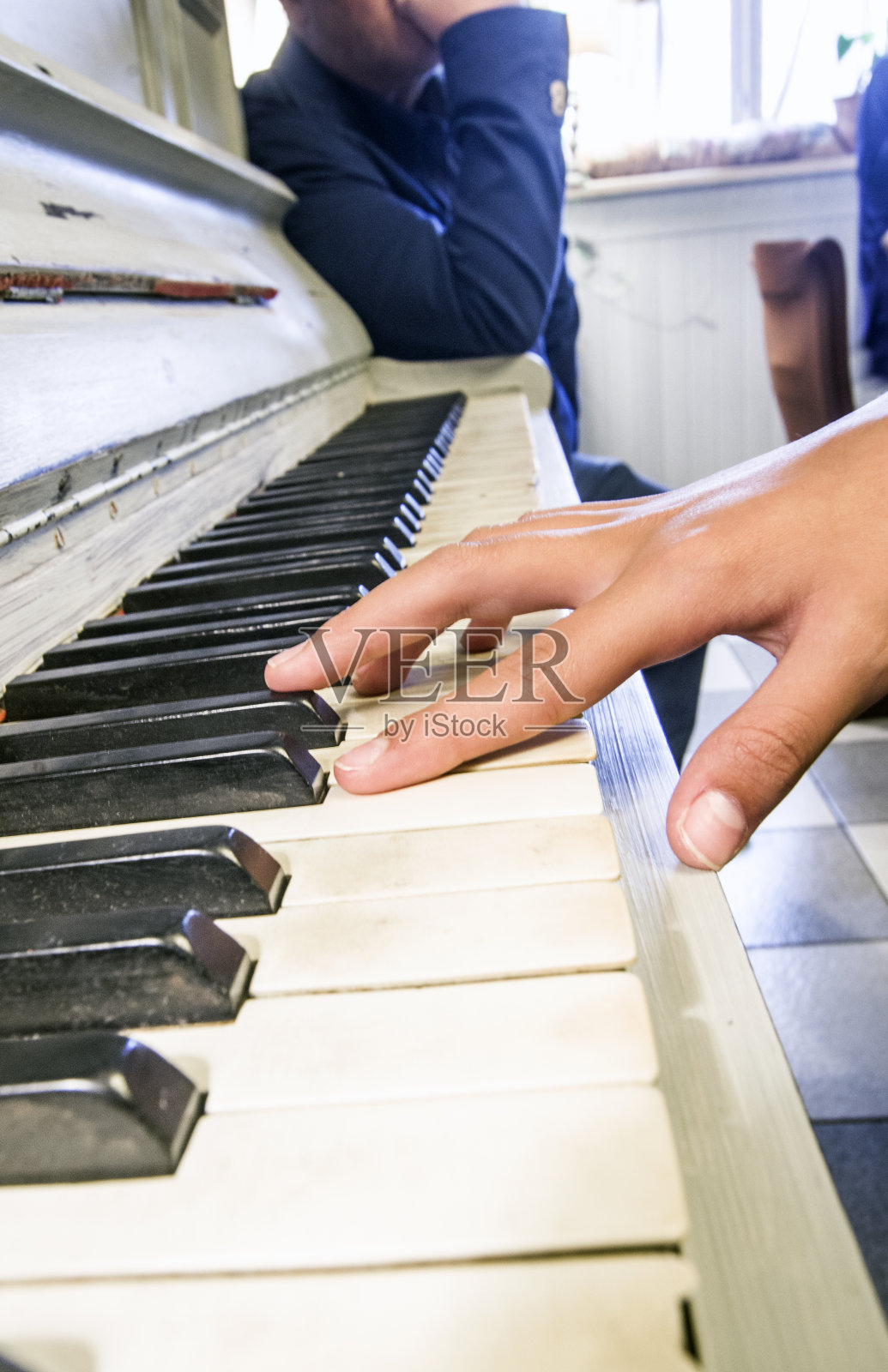 这位年轻的音乐家用双手弹奏着一架旧钢琴照片摄影图片