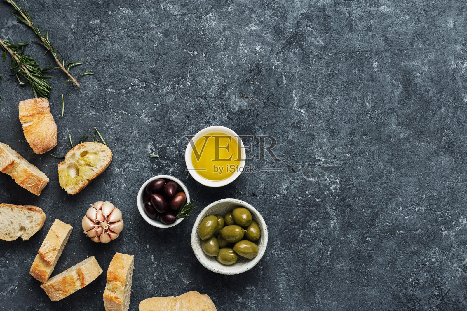 意大利烤面包，橄榄，新鲜的法棍面包片，橄榄油，大蒜，迷迭香照片摄影图片