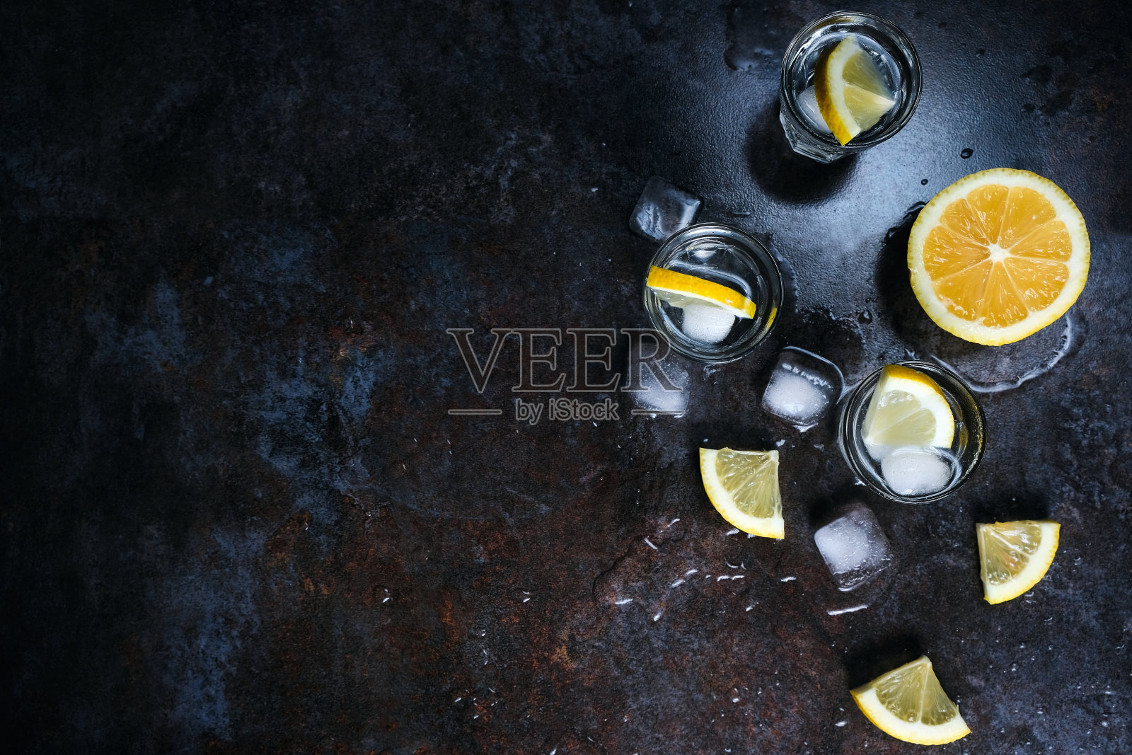 加柠檬和冰的玻璃杯伏特加。在黑色的石头桌上。Copyspace。照片摄影图片