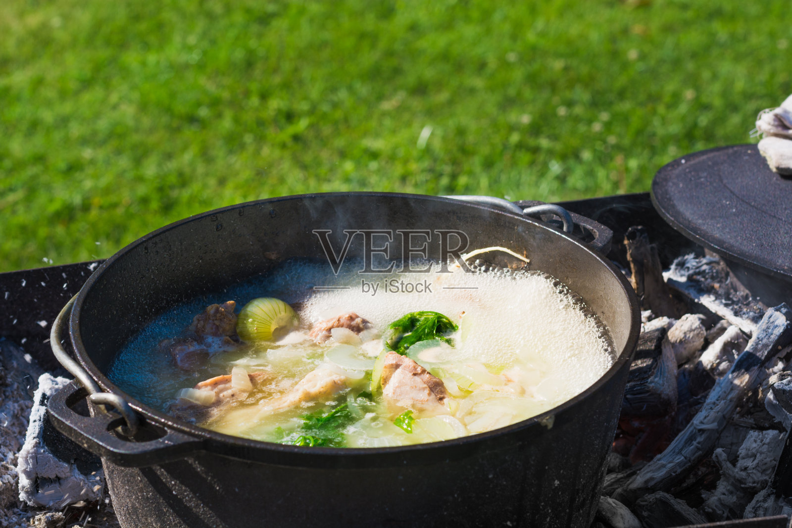 Shurpa汤在一个大铸铁锅户外。夏天徒步旅行的食物。照片摄影图片