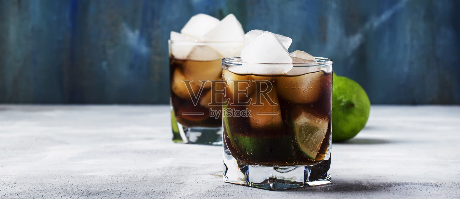 酒精鸡尾酒古巴自由与冰，酸橙，果汁，可乐和金色朗姆酒，灰色吧台，选择性焦点照片摄影图片
