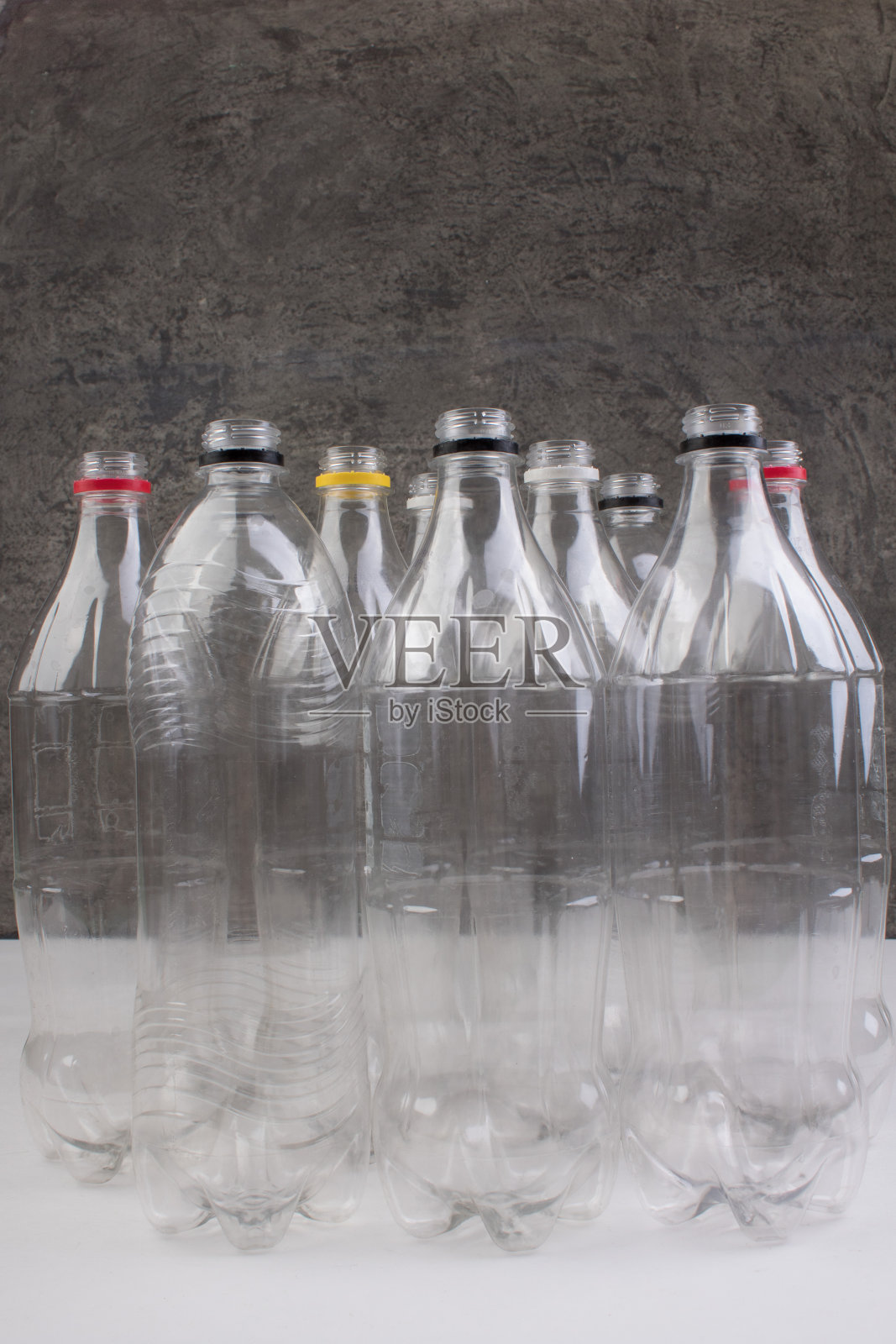 收集空的用过的塑料瓶在双锡，灰色背景。照片摄影图片