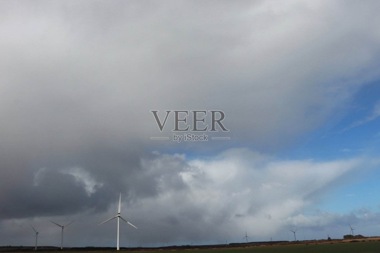 阴天下山顶上的风力涡轮机照片摄影图片