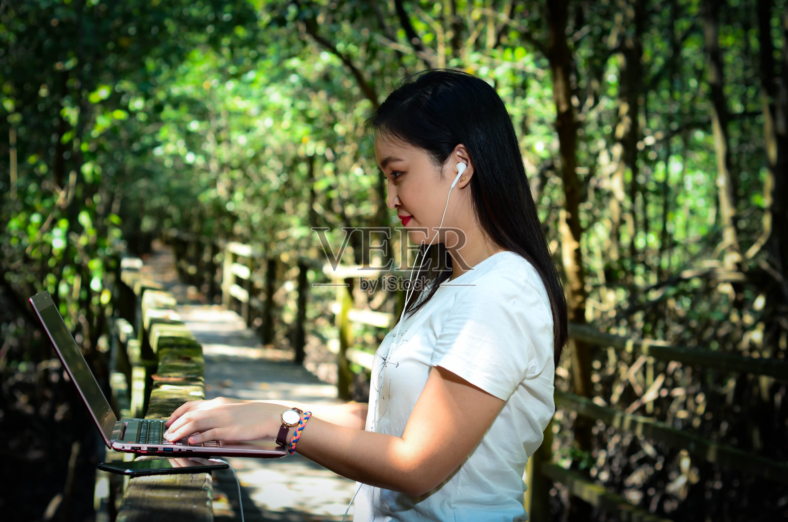 亚洲女性成年人在她的笔记本电脑上。照片摄影图片