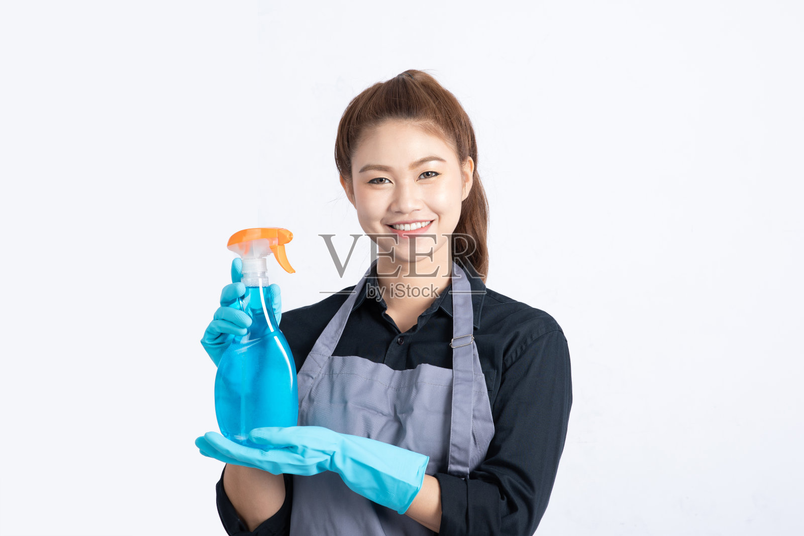 美丽迷人的亚洲女佣微笑，抱着清洁喷雾感觉幸福和自信，孤立在白色背景，清洁服务理念照片摄影图片