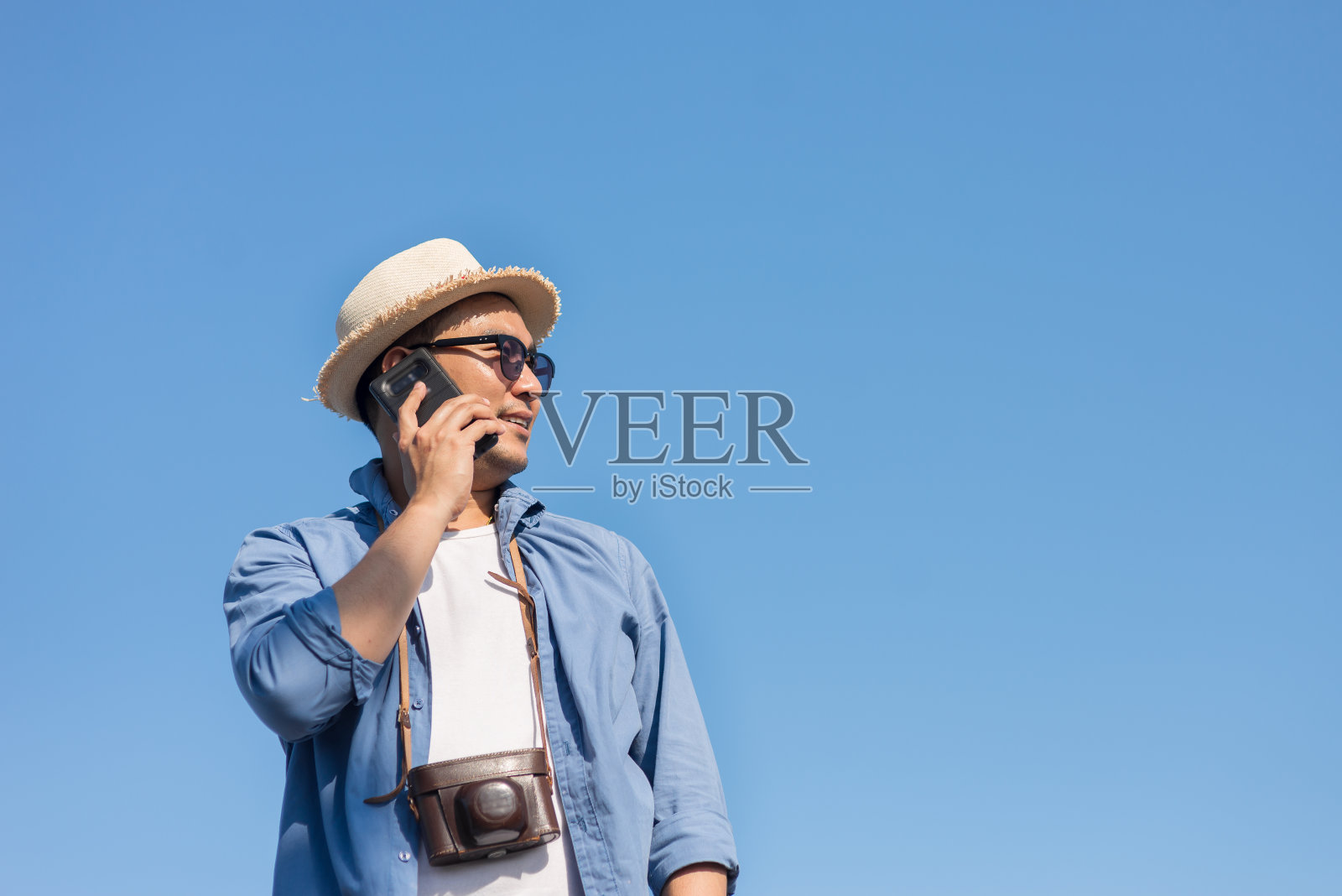 夏天，亚洲游客用手机与蓝天交谈。副本的空间。照片摄影图片