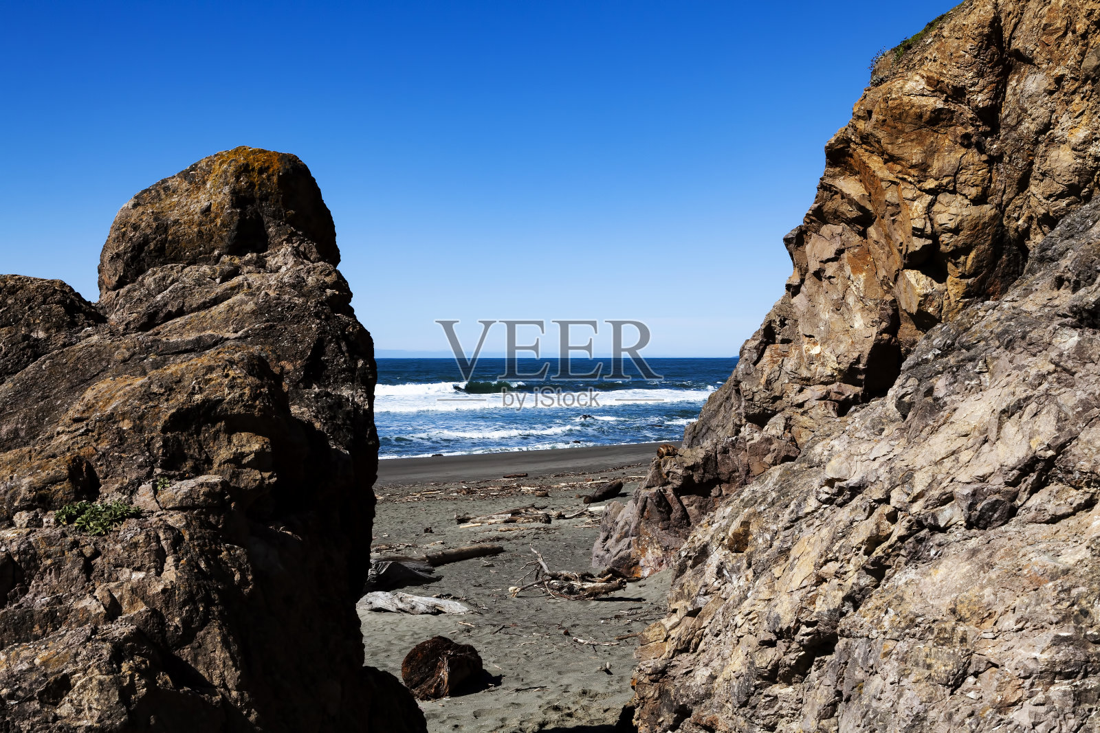 悬崖和岩石之间的海洋与蓝天照片摄影图片