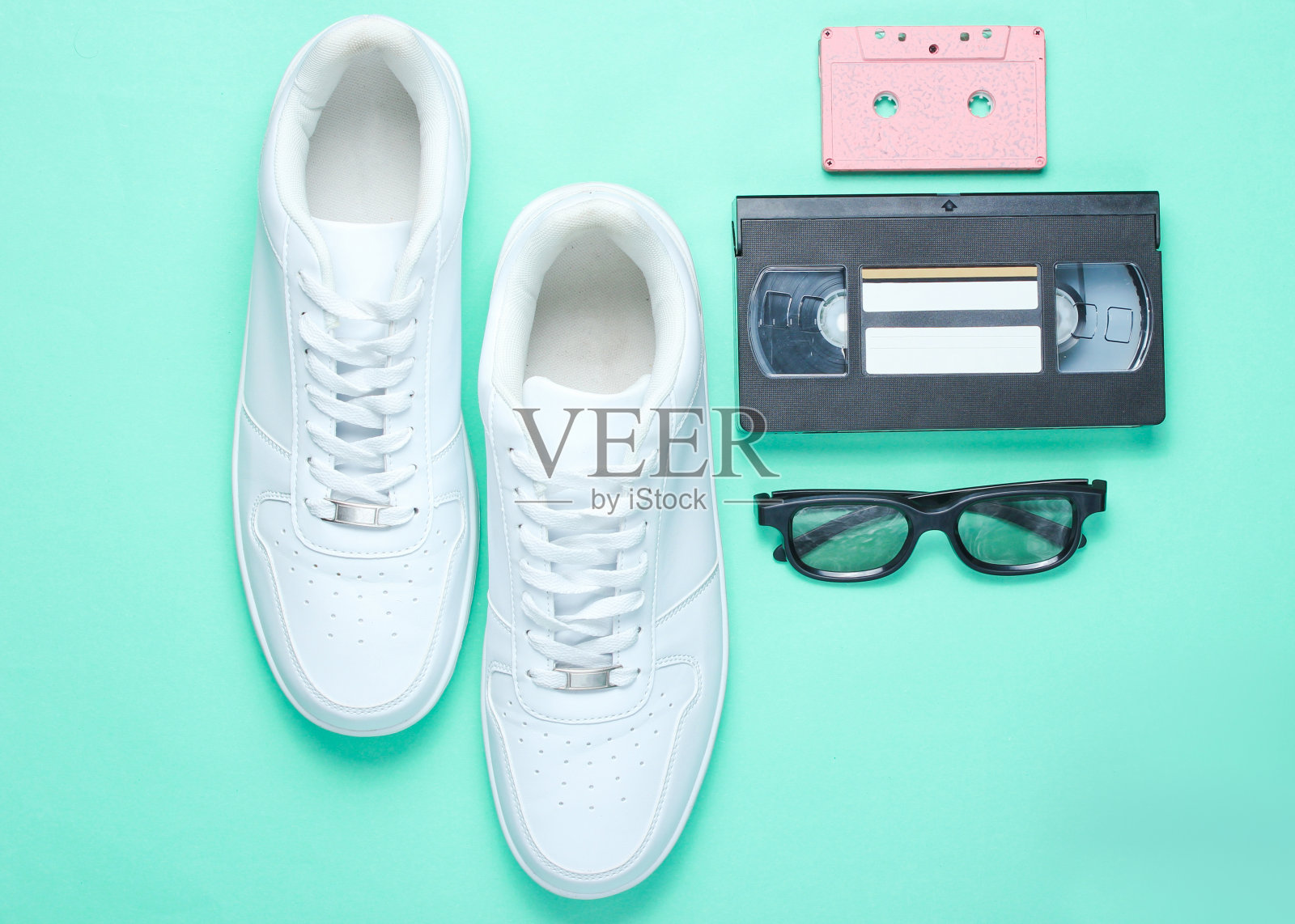 80年代,复古的风格。白色时尚运动鞋，音频和视频磁带，3D眼镜在薄荷色的纸背景。俯视图照片摄影图片