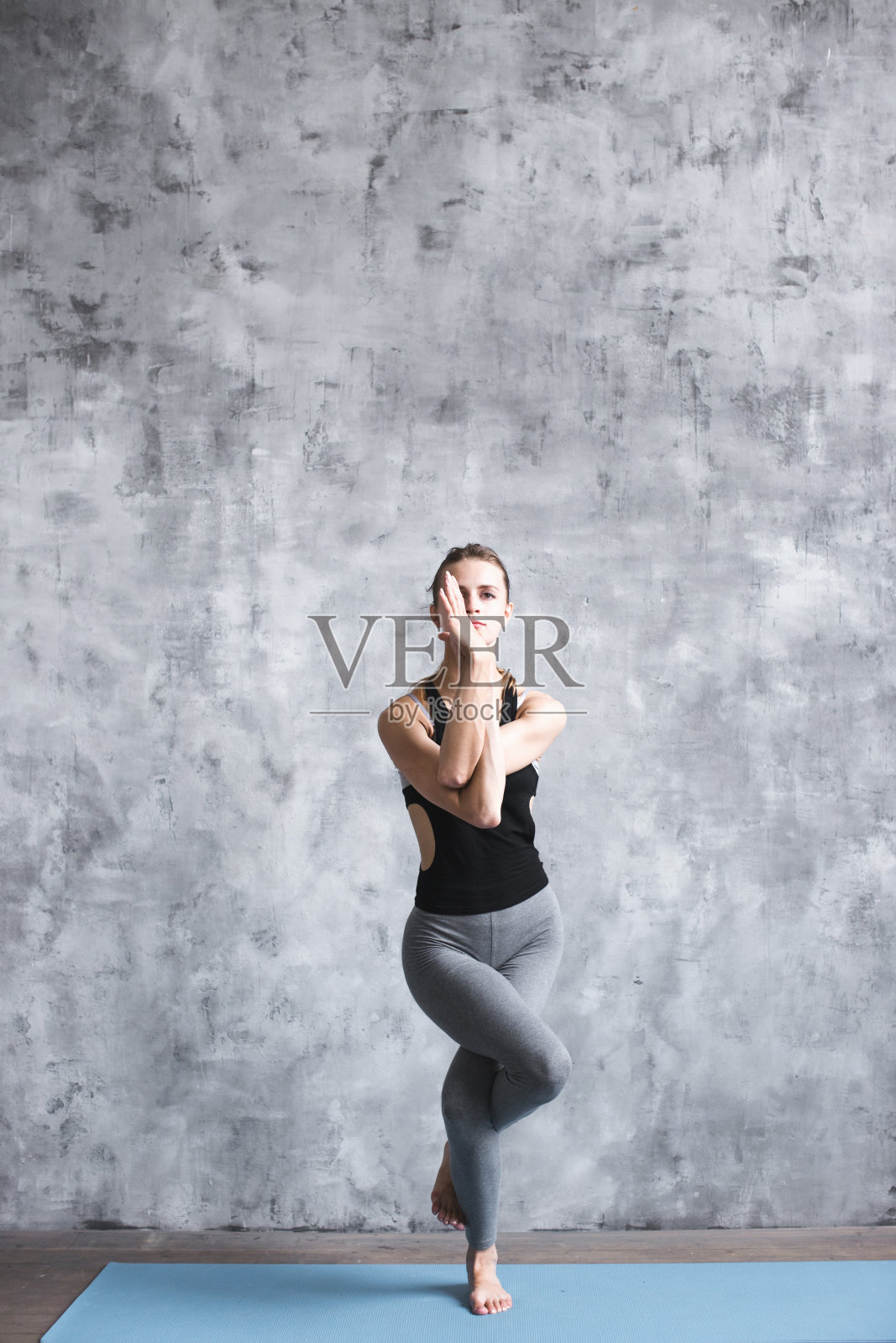 年轻美丽的女人在室内做瑜伽运动的全长肖像。照片摄影图片