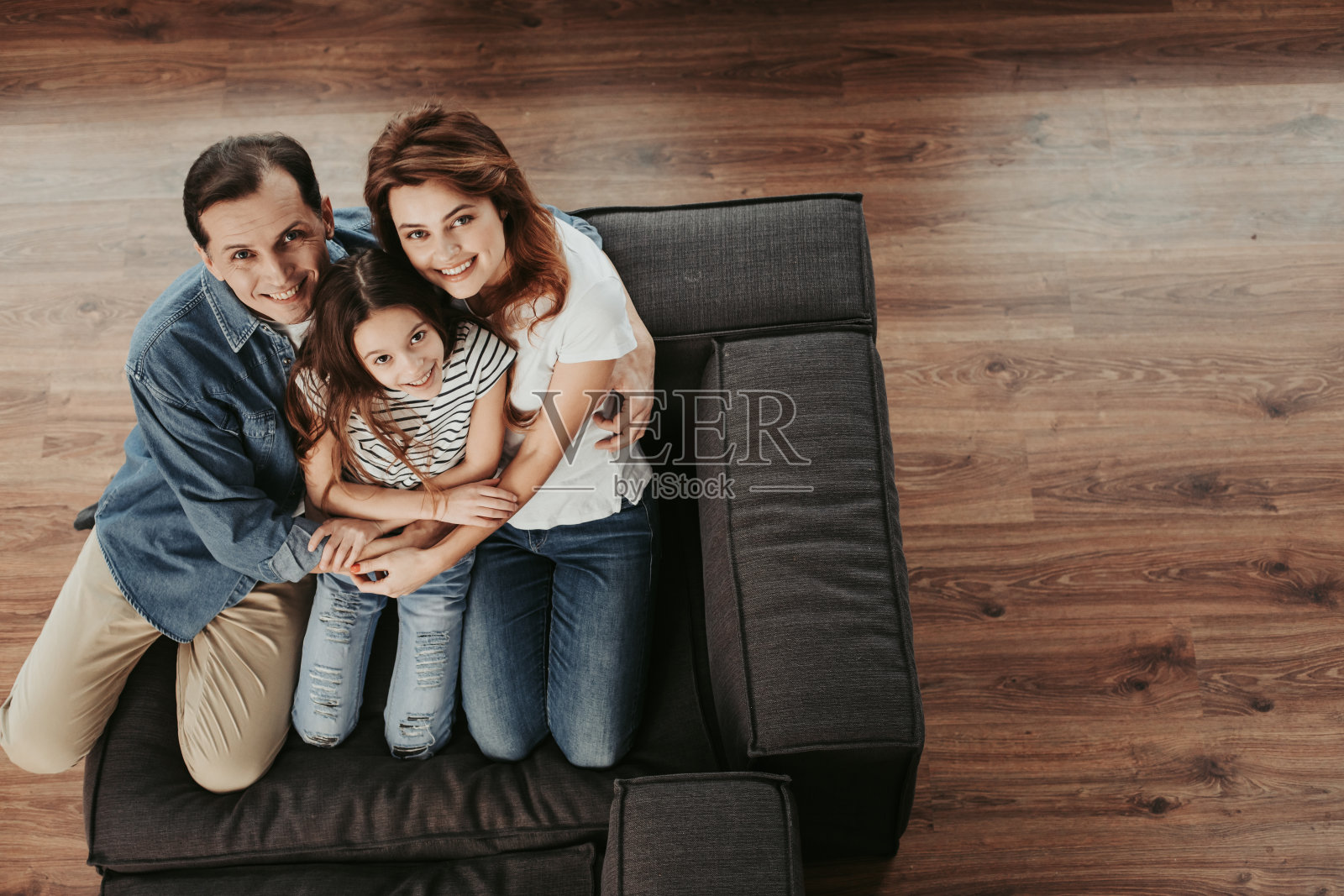 幸福的一家人坐在家里的沙发上照片摄影图片