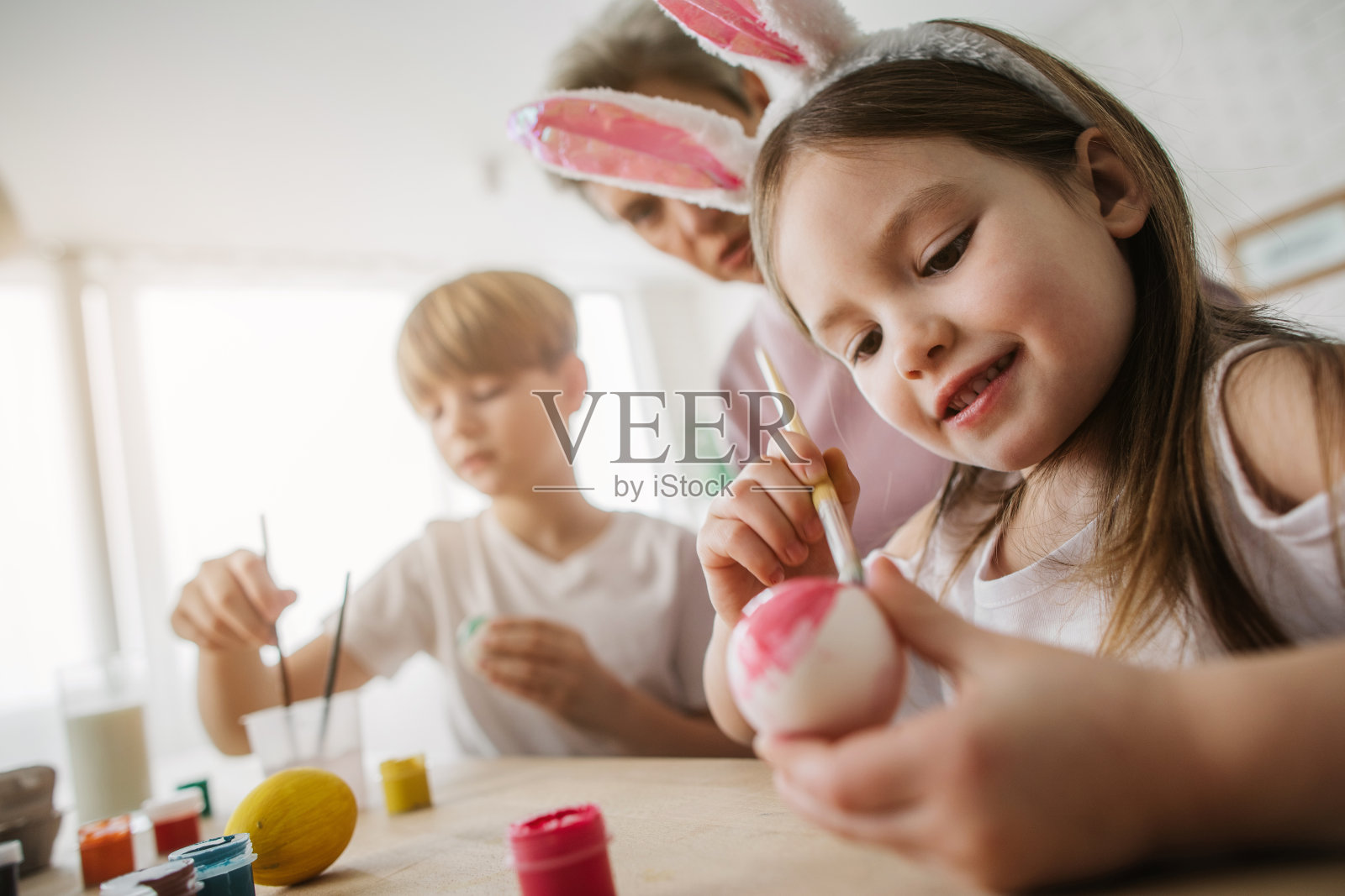 低角度的小女孩在厨房画复活节彩蛋照片摄影图片
