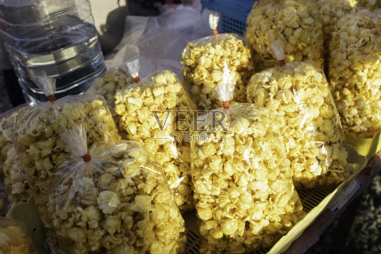 泰国当地市场的街边小吃摊上的袋装黄油甜爆米花。照片摄影图片