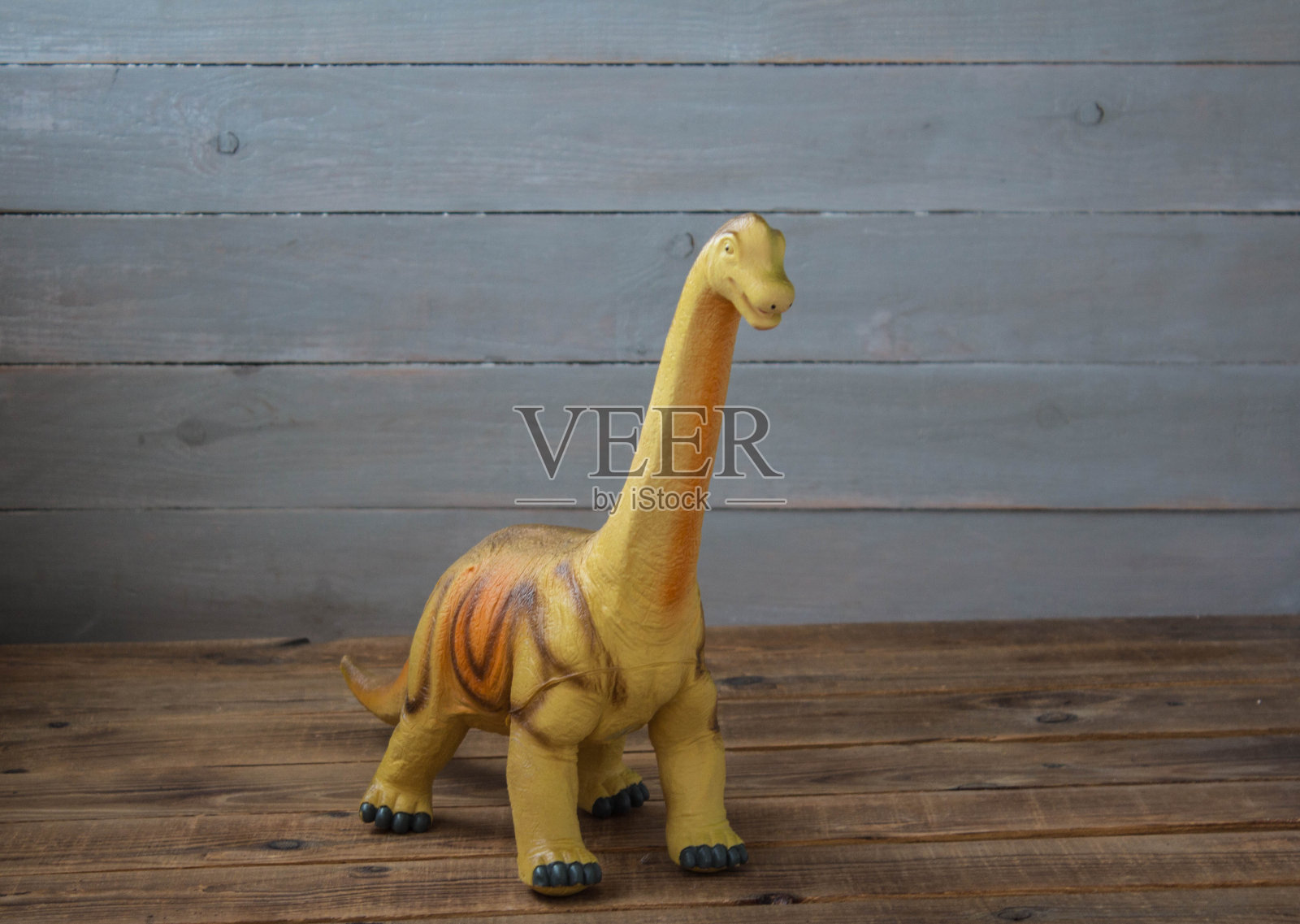 一个木制背景上的大恐龙儿童玩具照片摄影图片