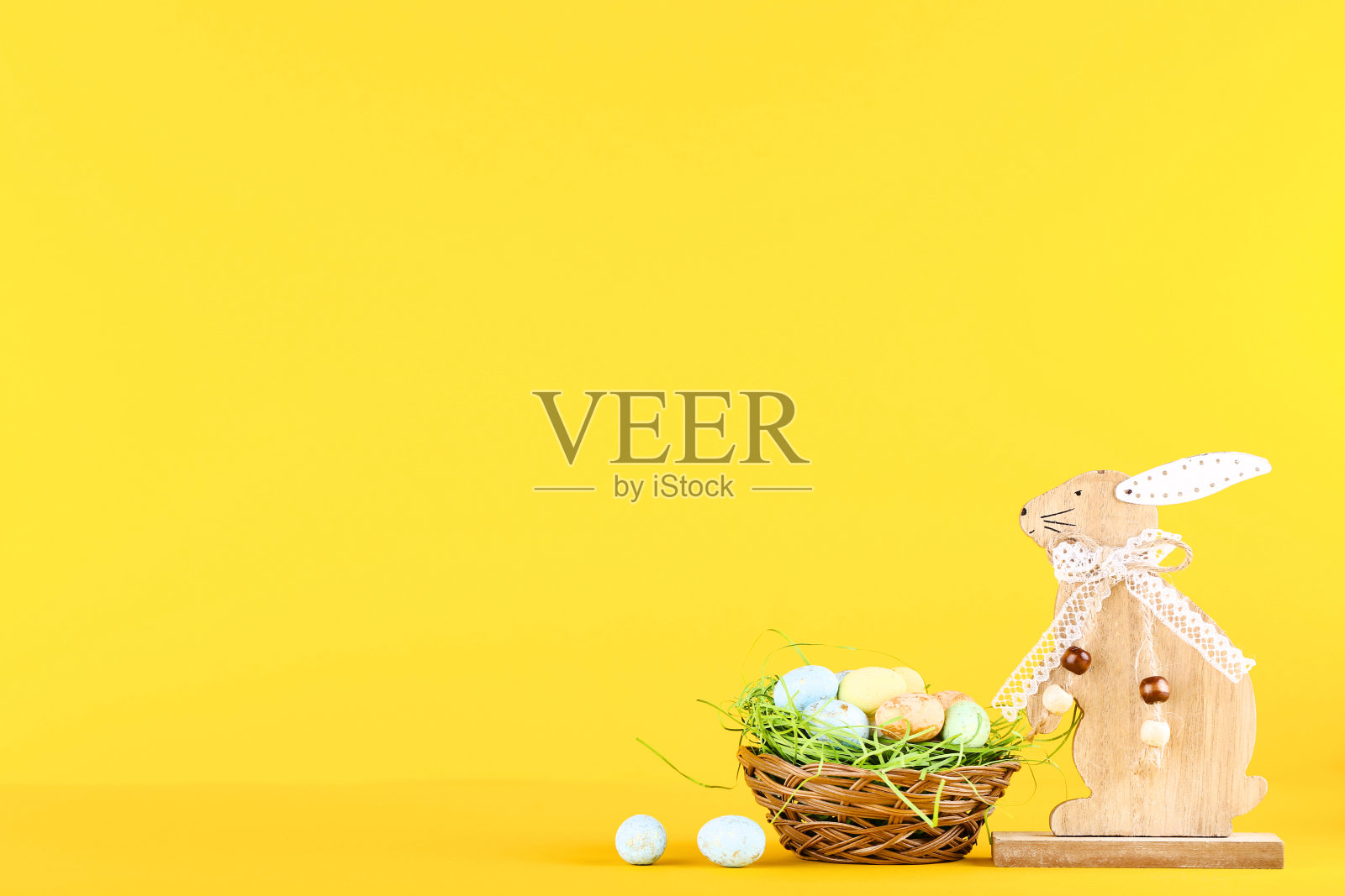 黄色背景的木制兔子复活节彩蛋照片摄影图片