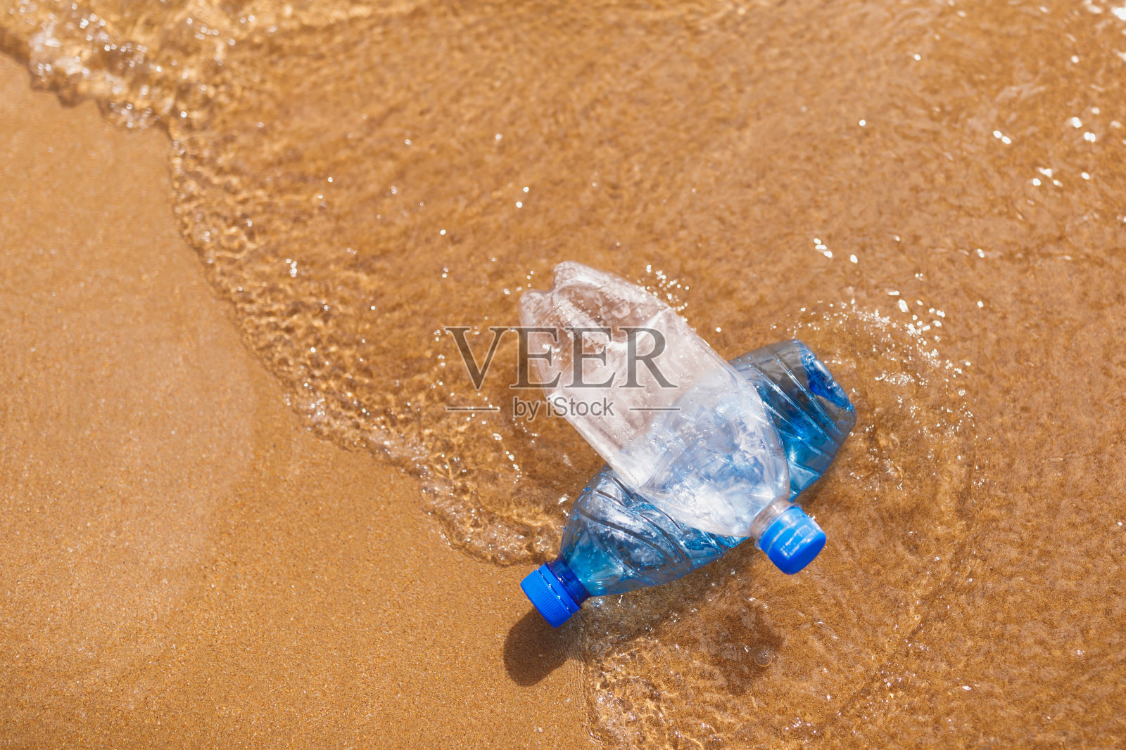 海滩上的废弃塑料瓶照片摄影图片