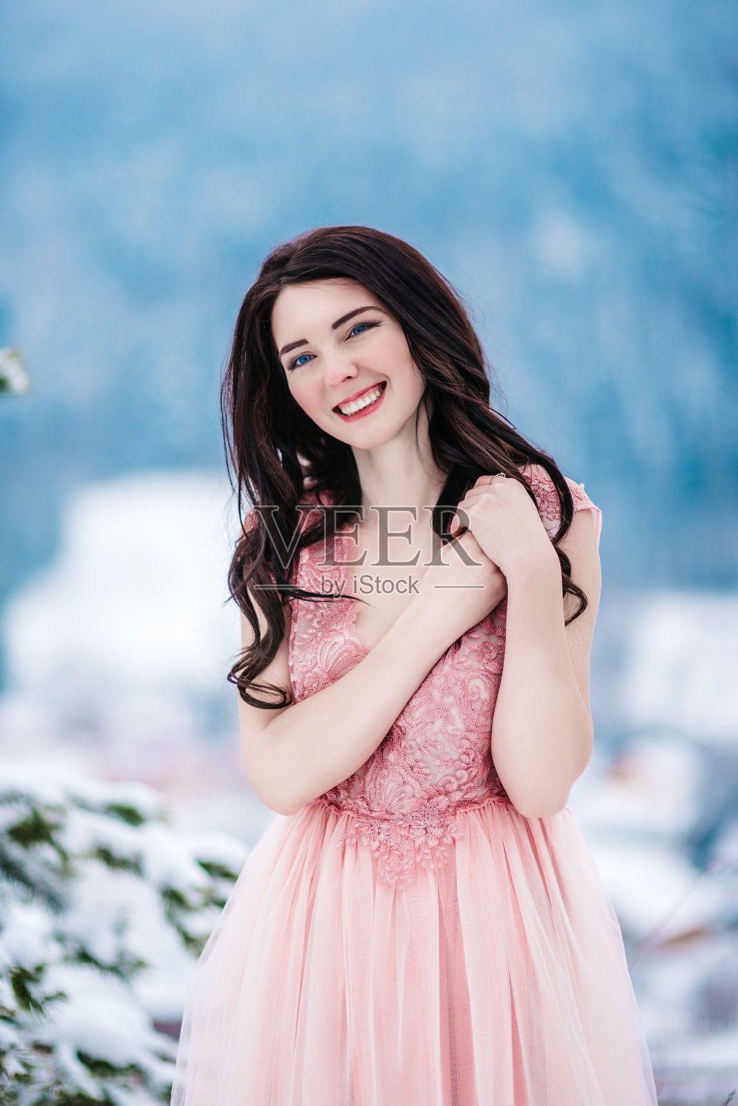 栗色头发的新娘，冬天群山的蓝色背景照片摄影图片
