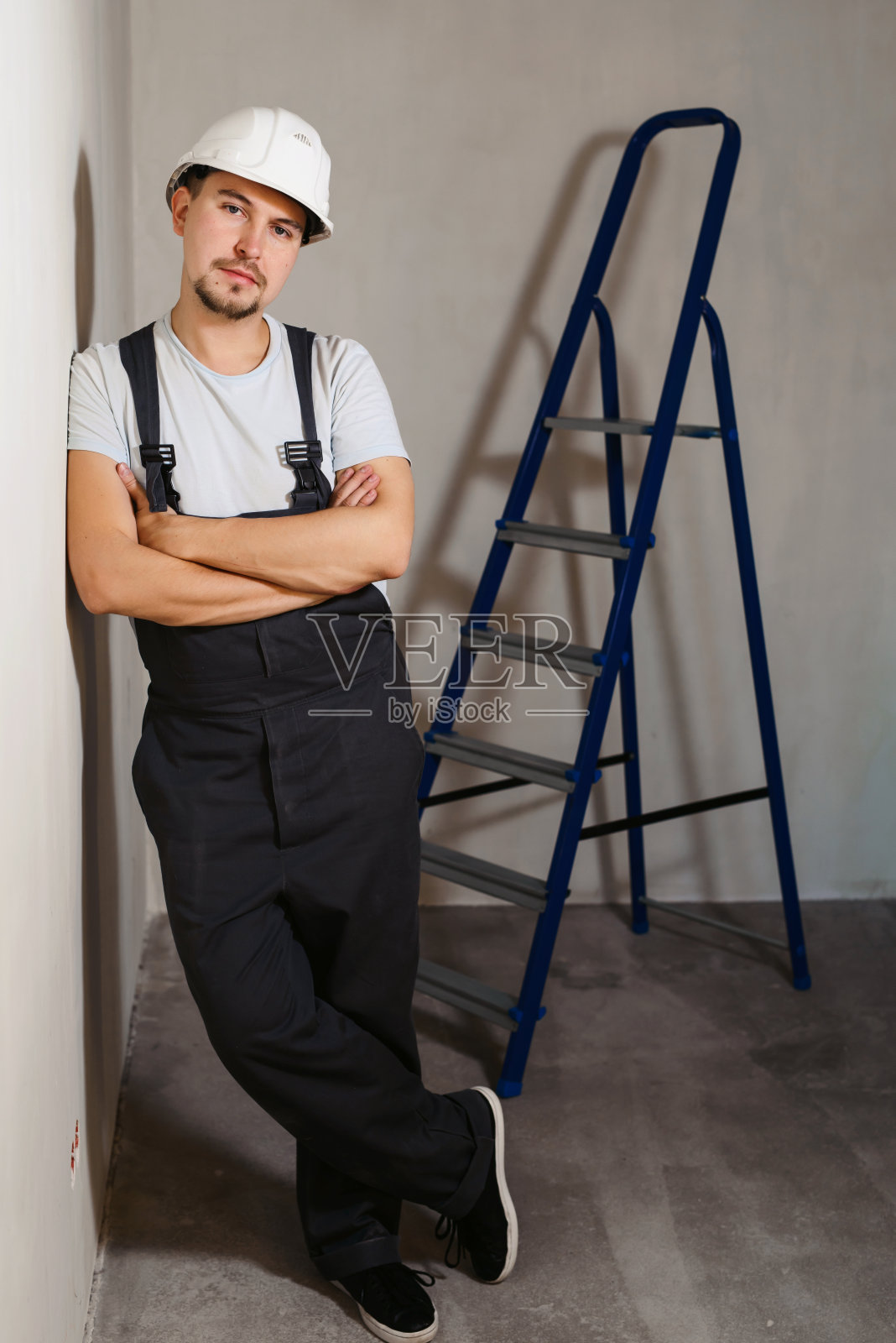 肖像的年轻男子工人工业工程师在制服和头盔站像一个老板在白色的背景孤立。安全设备。家庭装修的概念。Copyspace文本照片摄影图片