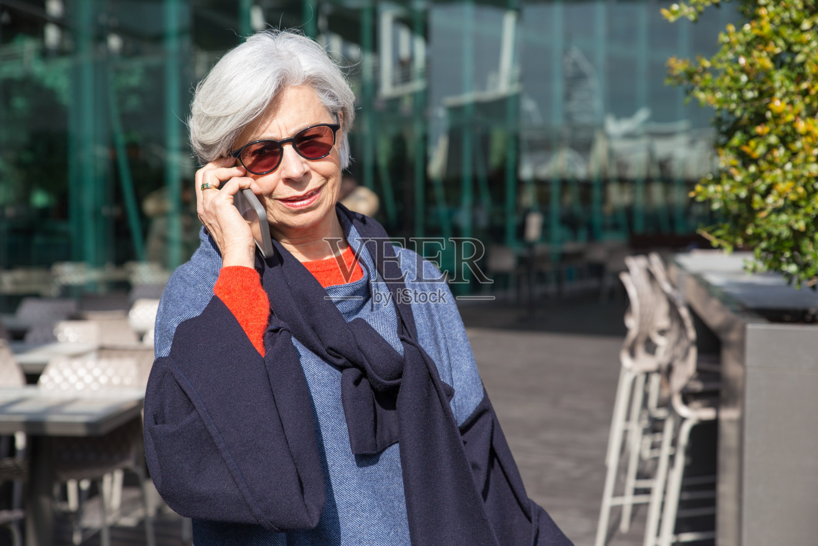 微笑的高级女性在户外用智能手机聊天照片摄影图片