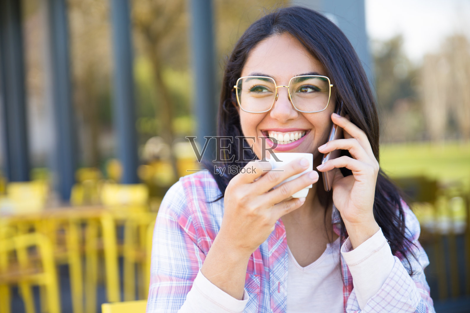 微笑的女人讲电话和喝咖啡在咖啡馆照片摄影图片