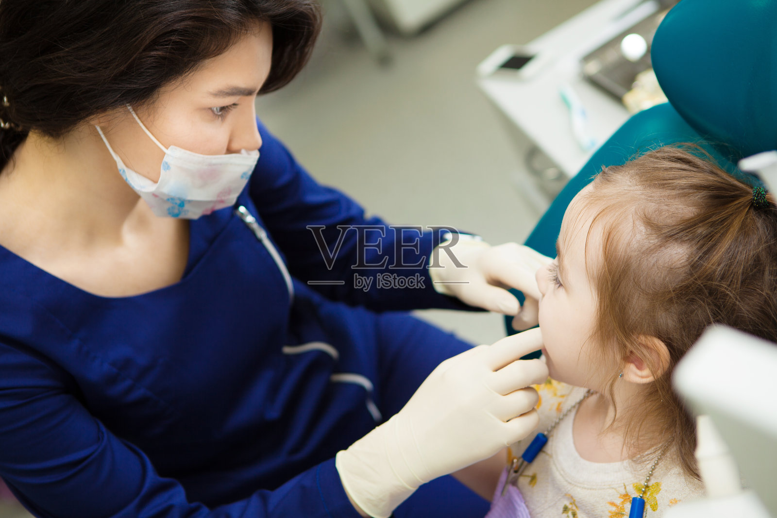 牙医戴着橡胶手套检查孩子的嘴照片摄影图片