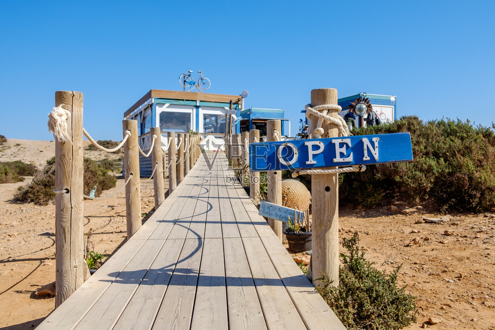 彩色的“开放”标志，在木板路的开始，通往一个乡村餐厅，在地中海海岸照片摄影图片