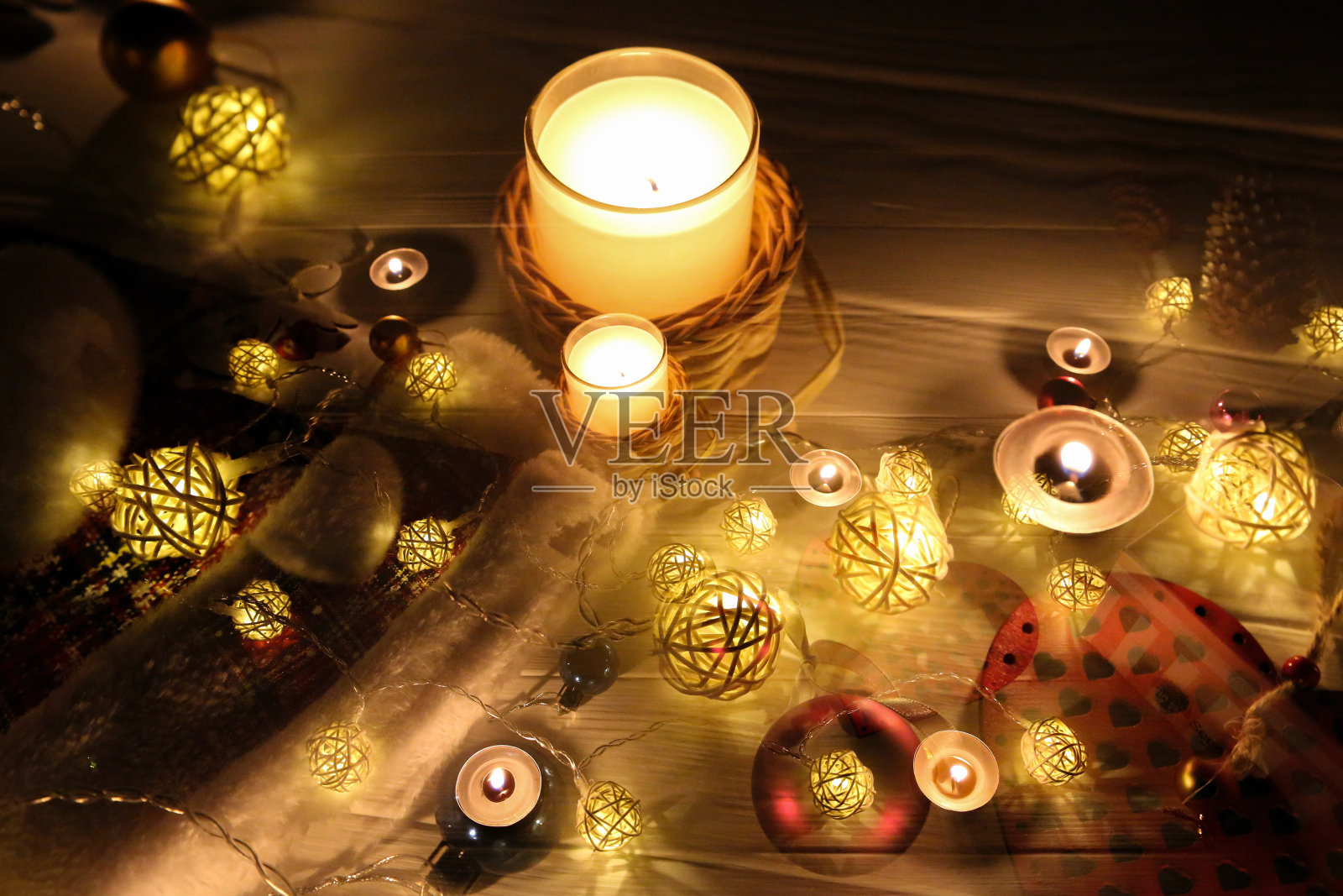 蜡烛在美丽的圣诞彩灯和花环装饰中燃烧。新年喜庆的背景。礼物，礼物，寒假贺卡。照片摄影图片