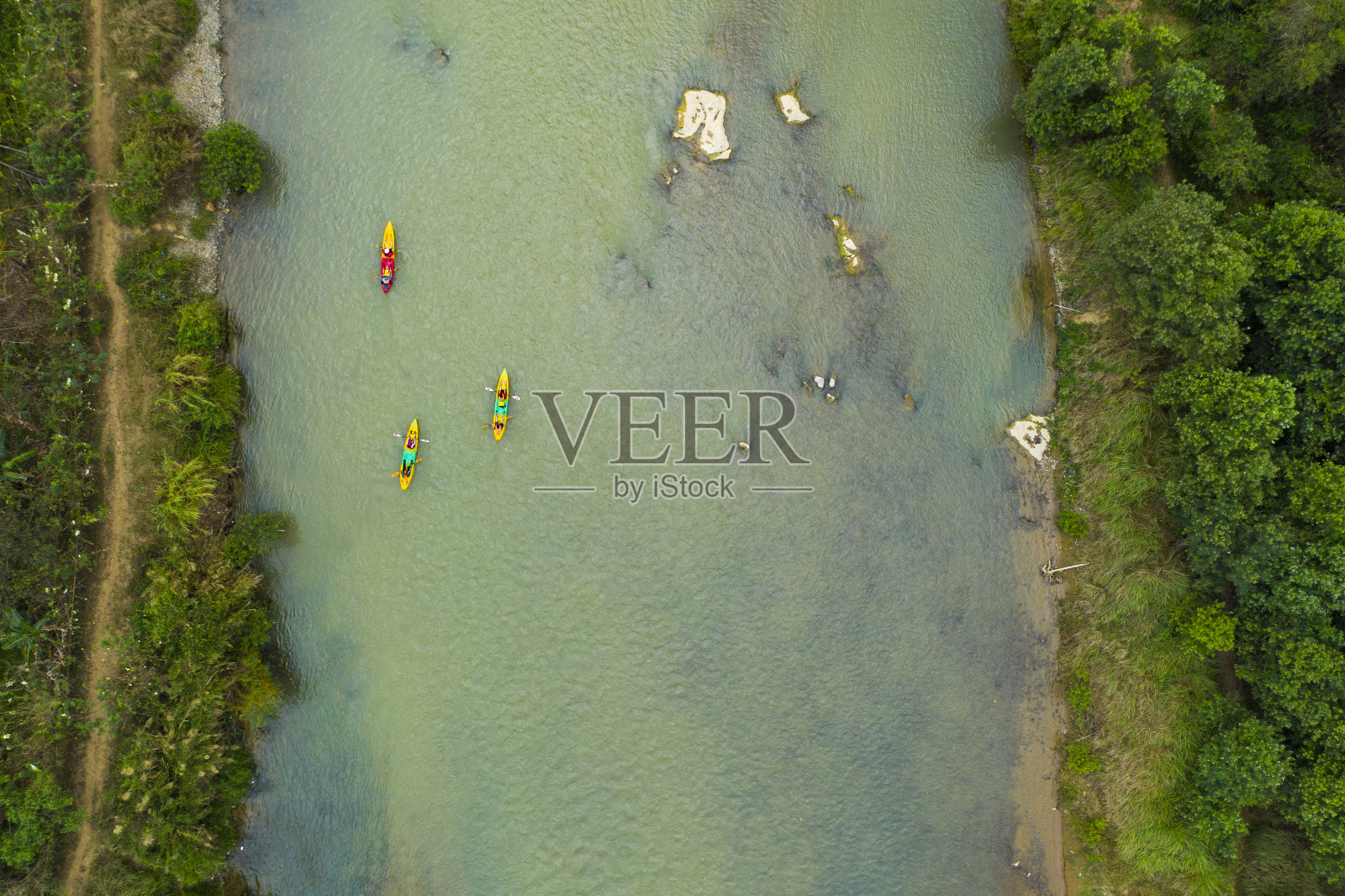 从上面俯瞰，一些游客在流经Vang Vieng村的河流上划独木舟的令人惊叹的鸟瞰图。万荣位于老挝万象以北，大约四小时的公交车车程。照片摄影图片