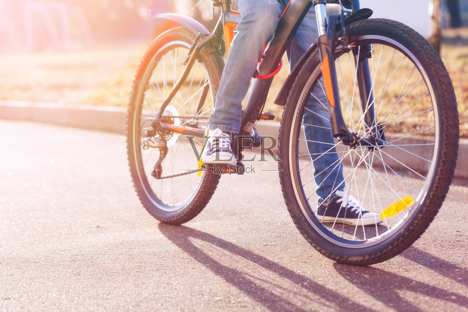 夏日清晨，孩子们骑着自行车在柏油路上照片摄影图片