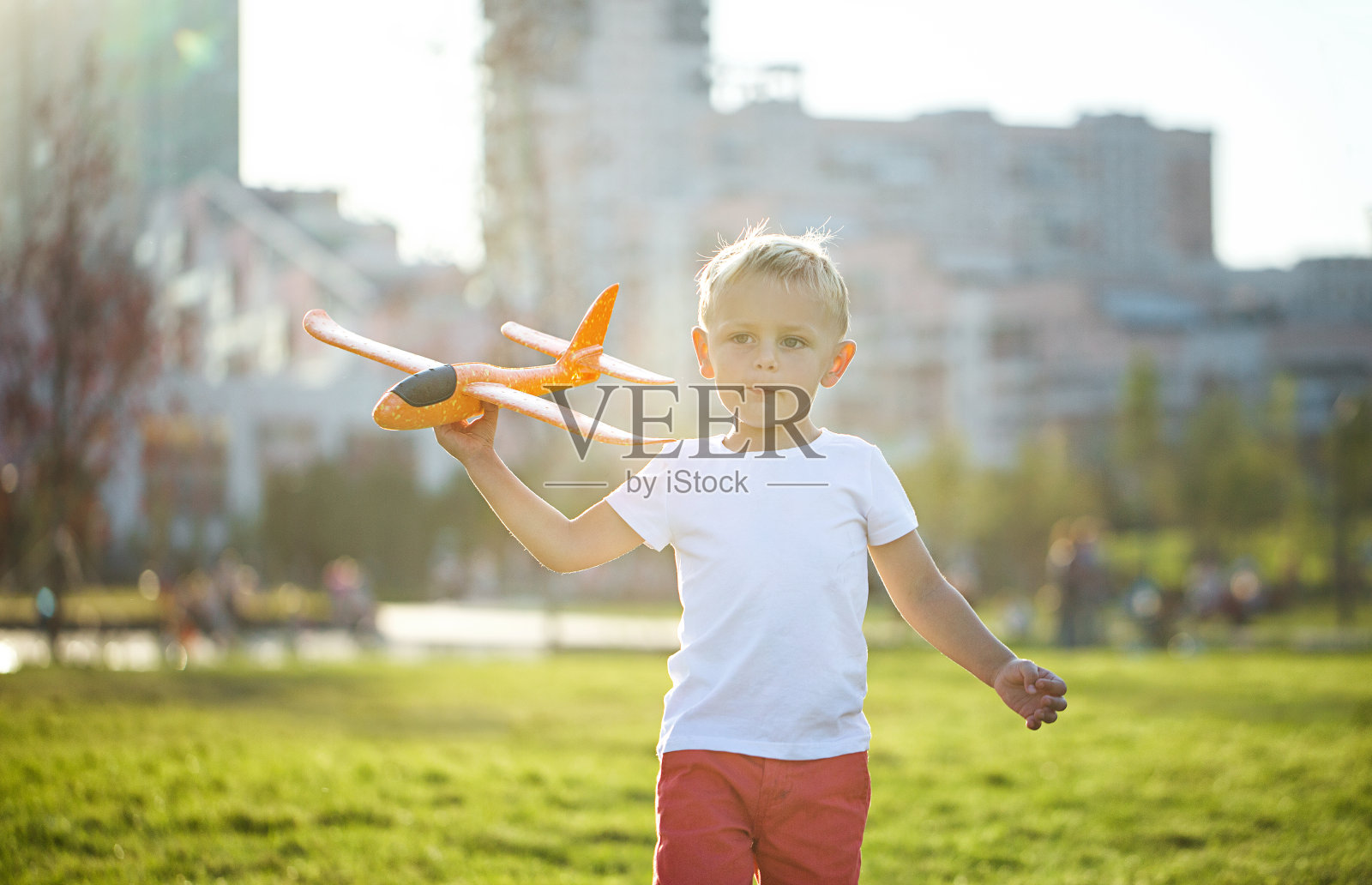 小男孩在玩橙色的飞机照片摄影图片