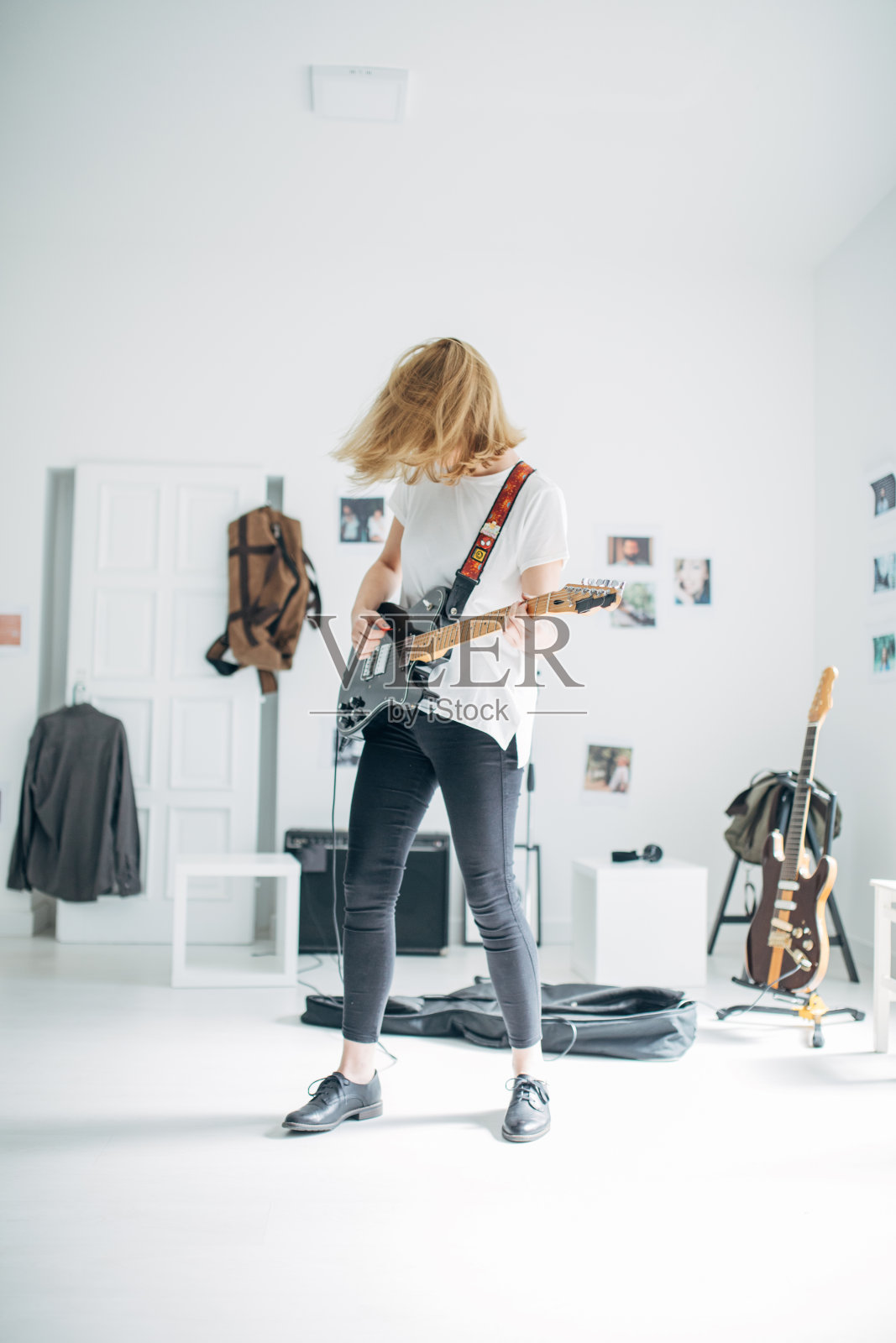 在音乐工作室弹电吉他的年轻女士照片摄影图片