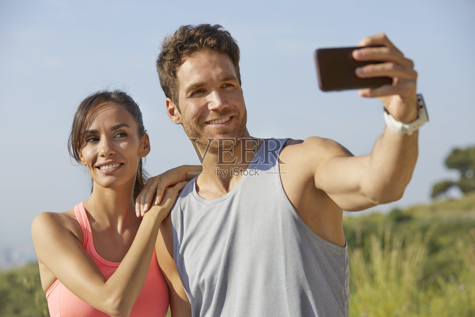 微笑的情侣通过智能手机自拍照片摄影图片