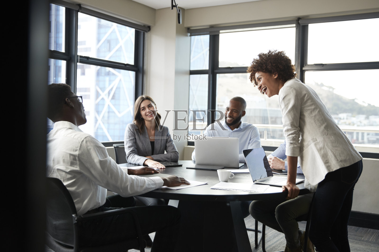 在一次会议上，千禧一代黑人女商人站着倾听公司同事的声音照片摄影图片