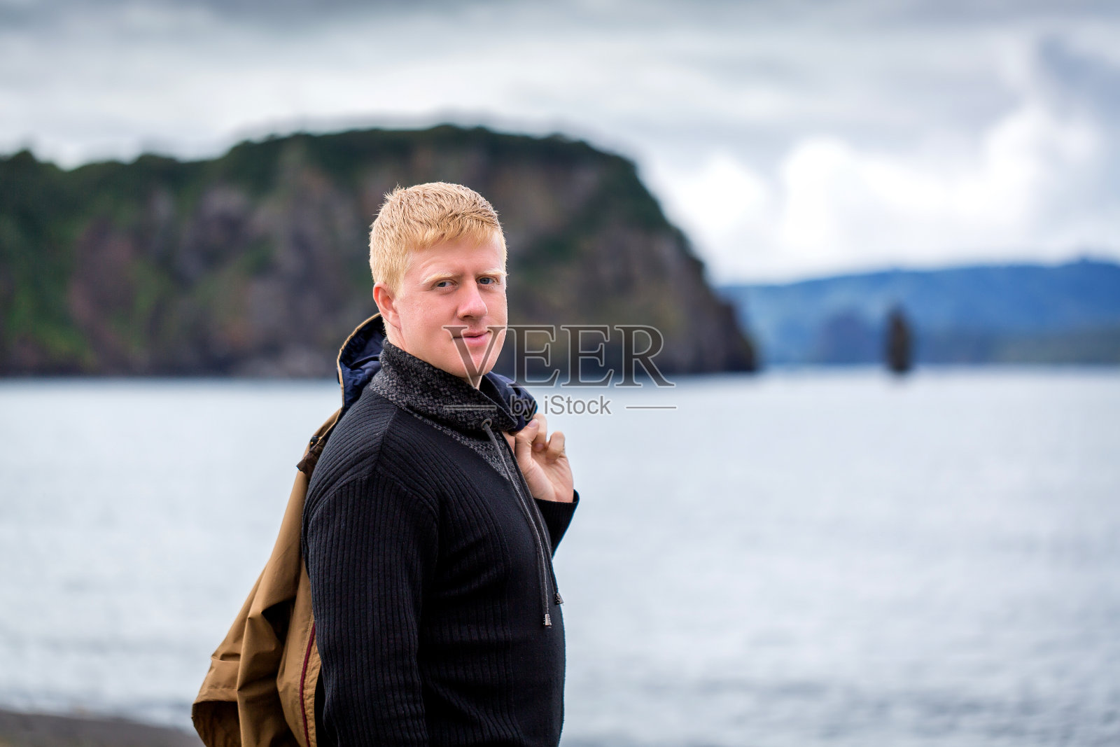一名男子站在堪察加半岛的阿瓦查湾海岸。照片摄影图片