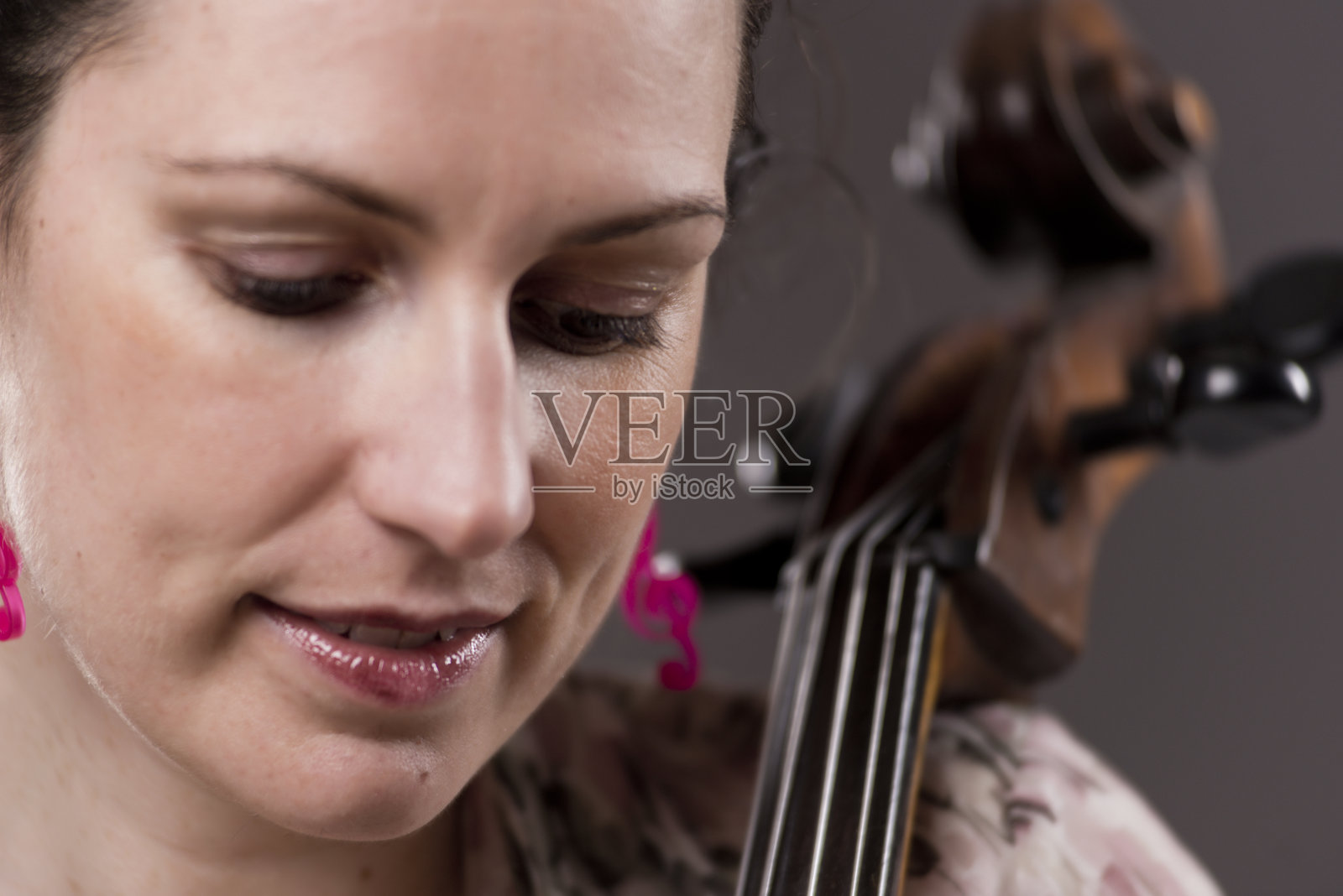 一个美丽的黑发热情的女性大提琴手的特写肖像照片摄影图片