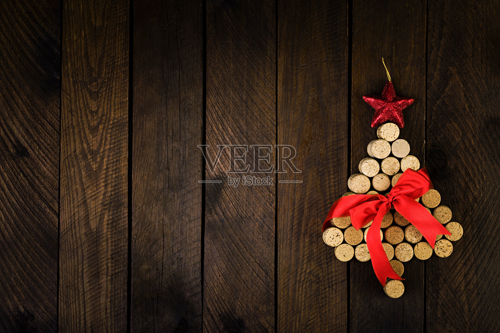 在木制背景上用葡萄酒软木塞制成的圣诞树。模拟明信片与圣诞树和文本复制空间。前视图。插画图片素材