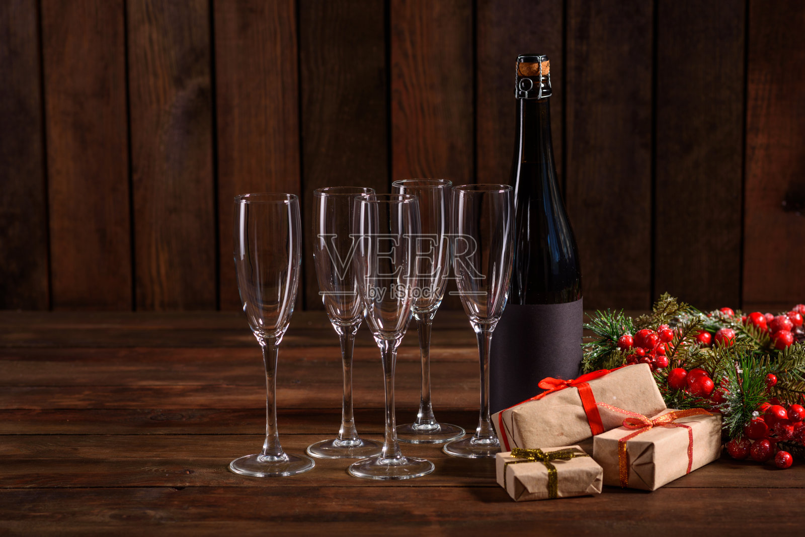 圣诞假期餐桌上放着玻璃杯和一瓶香槟照片摄影图片
