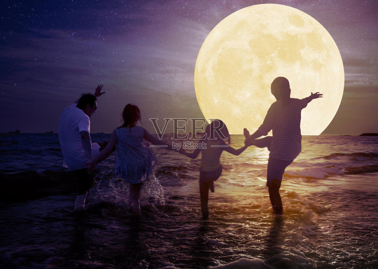 一家人在沙滩上玩，看月亮。庆祝中秋节的概念照片摄影图片